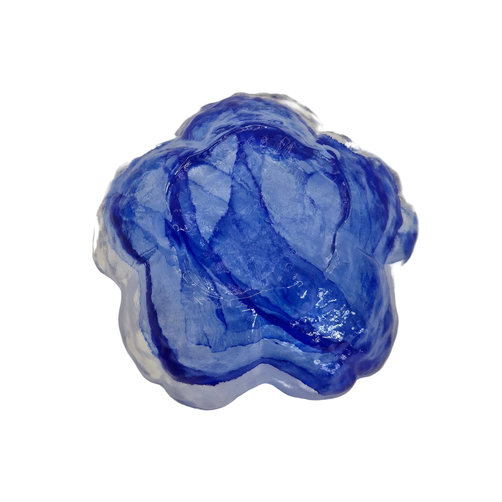 A scalloped glass bowl or trinket dish with a vibrant cobalt blue wave design showing the underneath side, shown on a plain white background.