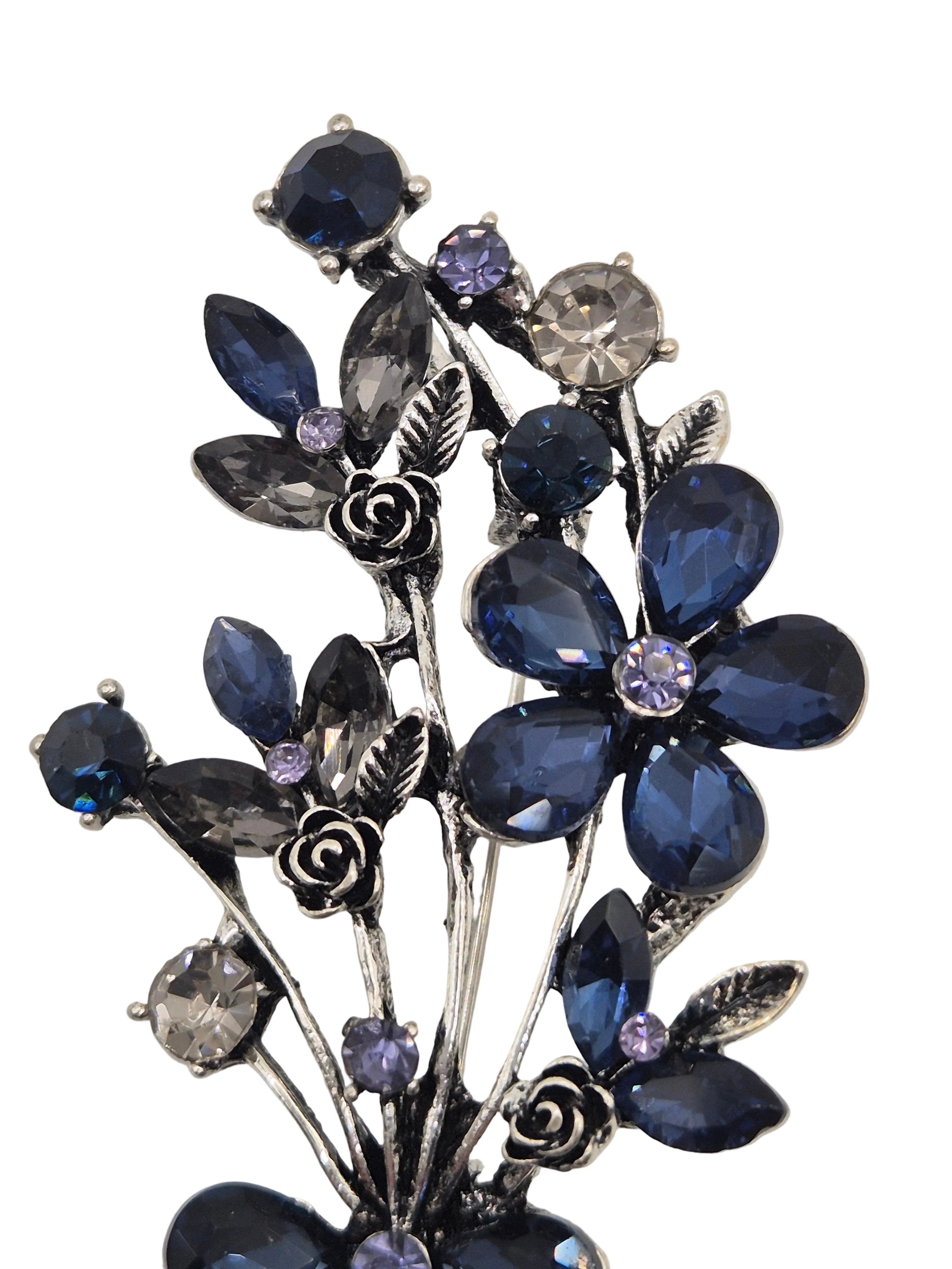 Decorative brooch with blue gemstone flowers on a white background