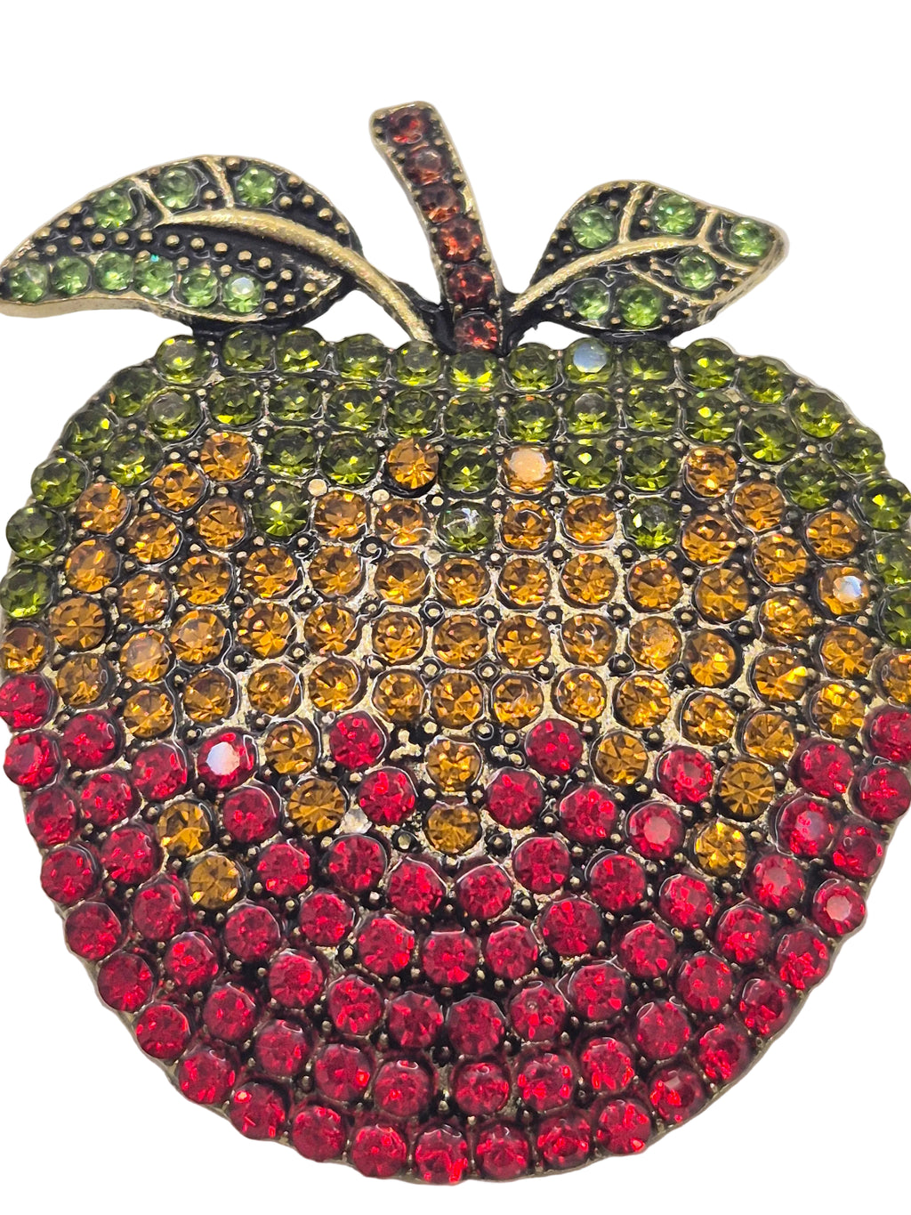 red rhinestone apple-shaped brooch on a gray background