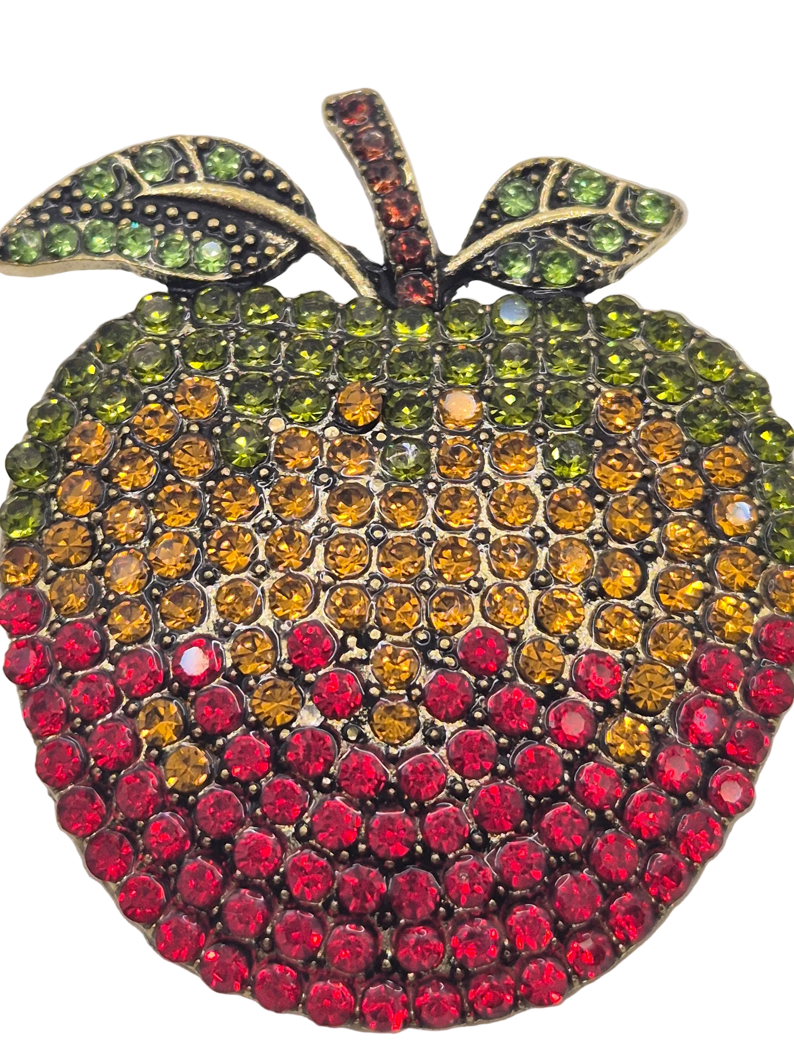 red rhinestone apple-shaped brooch on a gray background