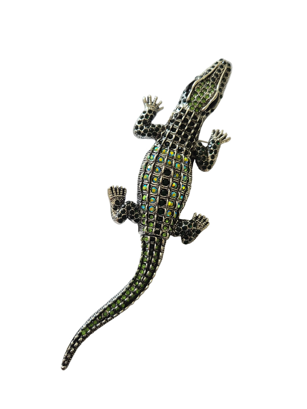 Silver crocodile brooch with green gemstones on a white background