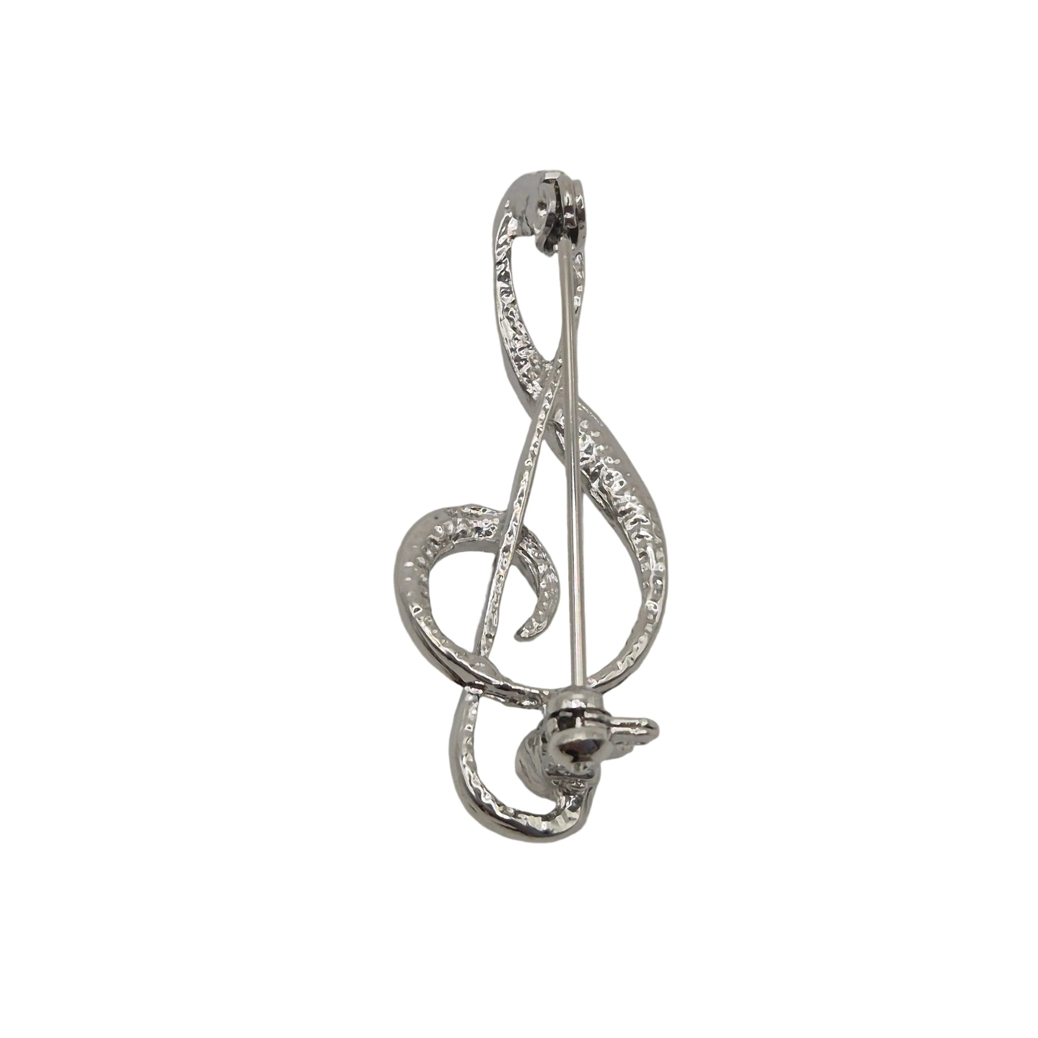 A silver-tone metal pin shaped like a treble clef, photographed on a plain white background.