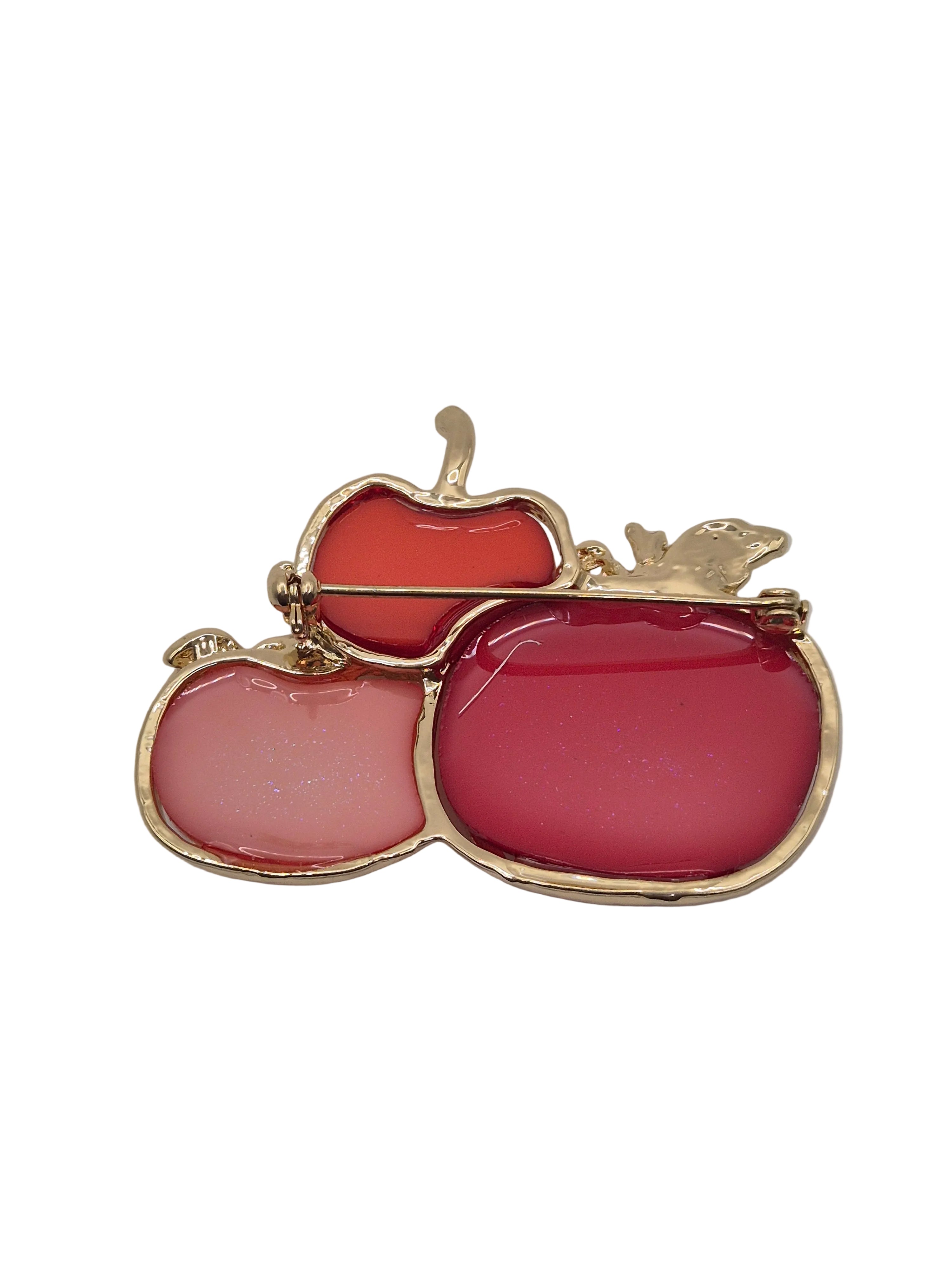 A brooch featuring 3 pumpkins in three shades of pink and coral, set against a plain light gray background.