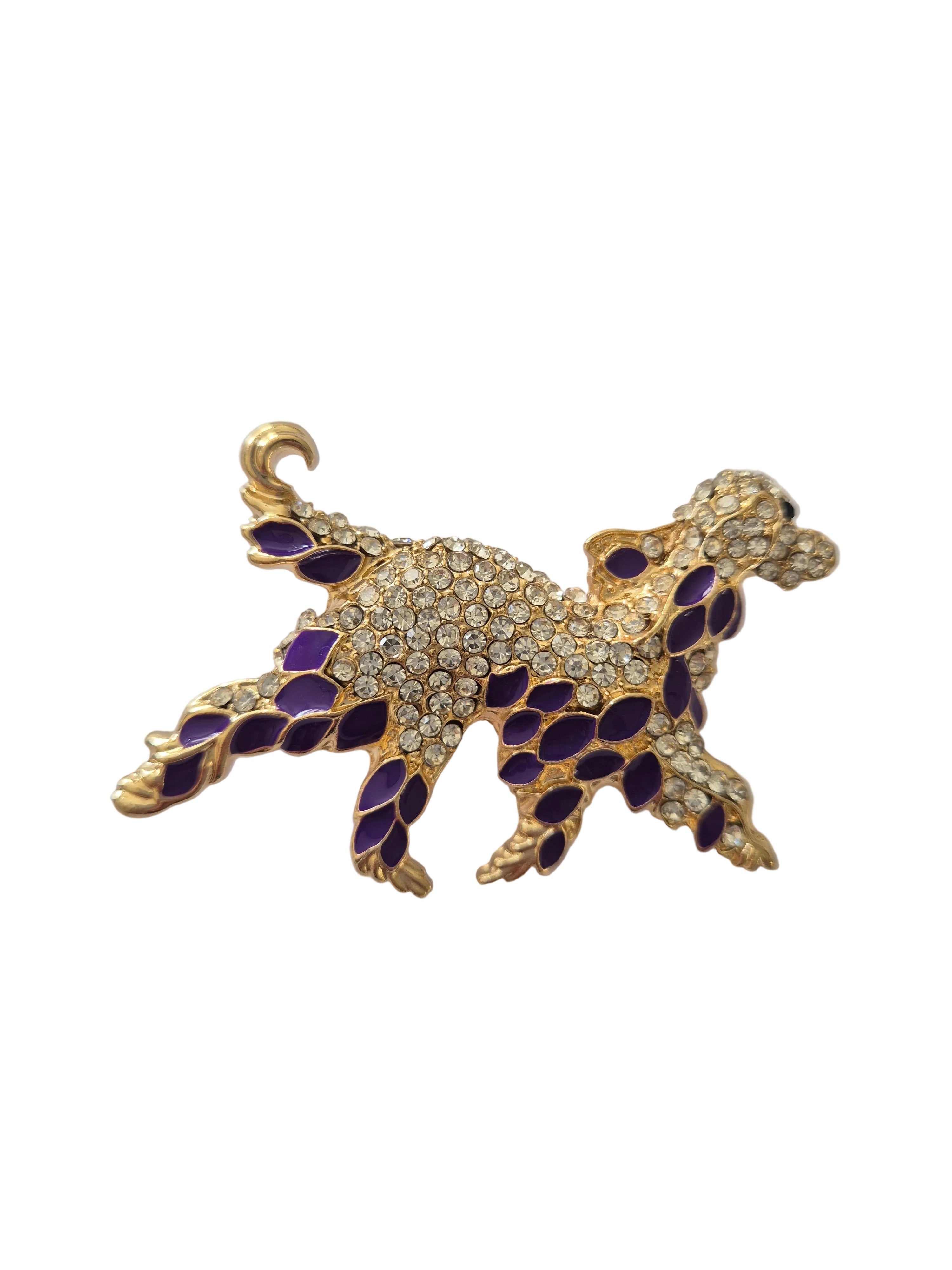 Gold and purple dog-shaped brooch on a white background