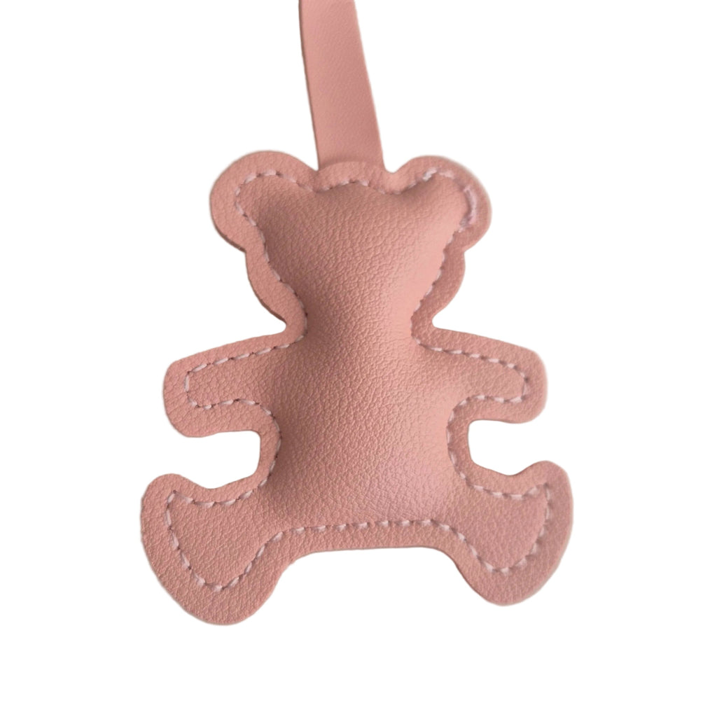 A light pink faux leather teddy bear bag charm with a matching pink loop, shown on a neutral white background.