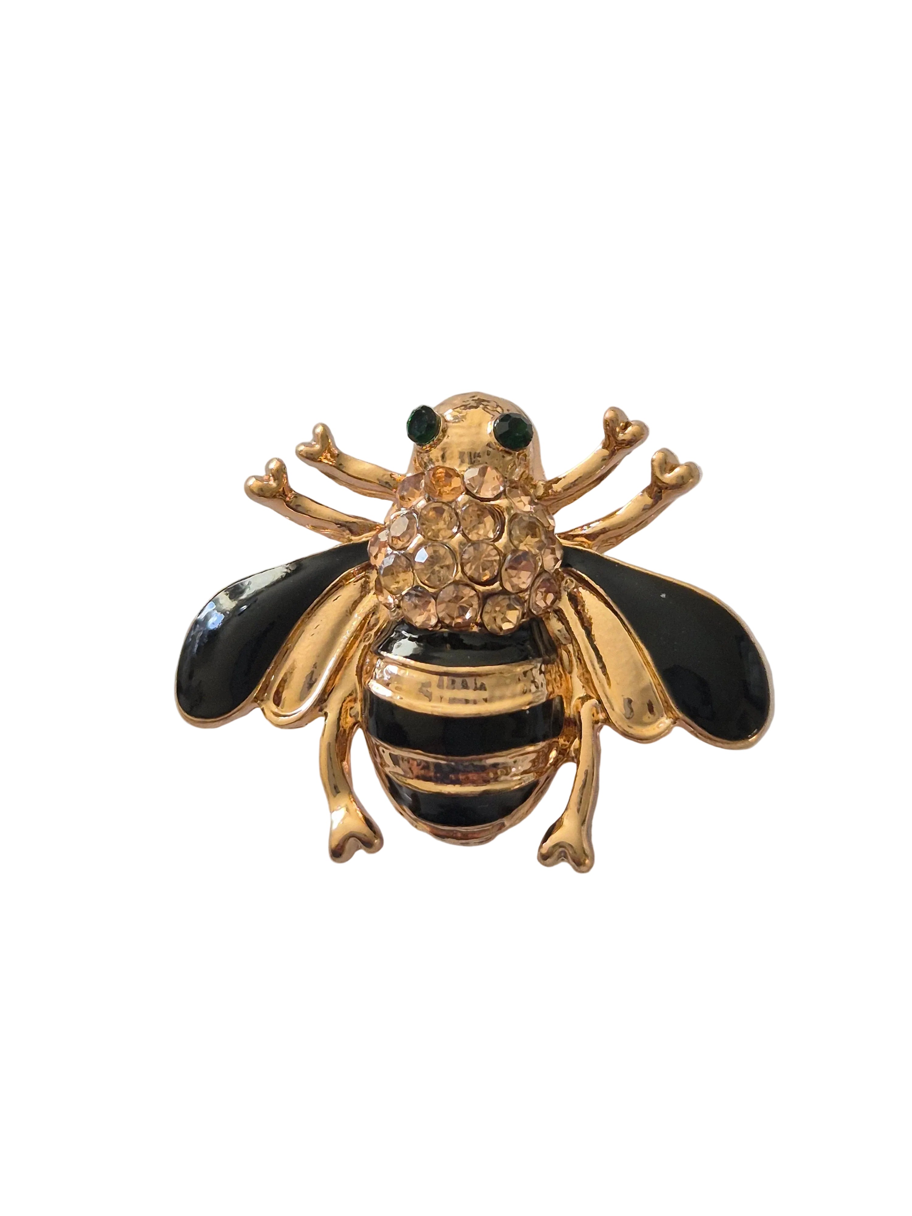 black and gold rhinestone bee brooch on white background