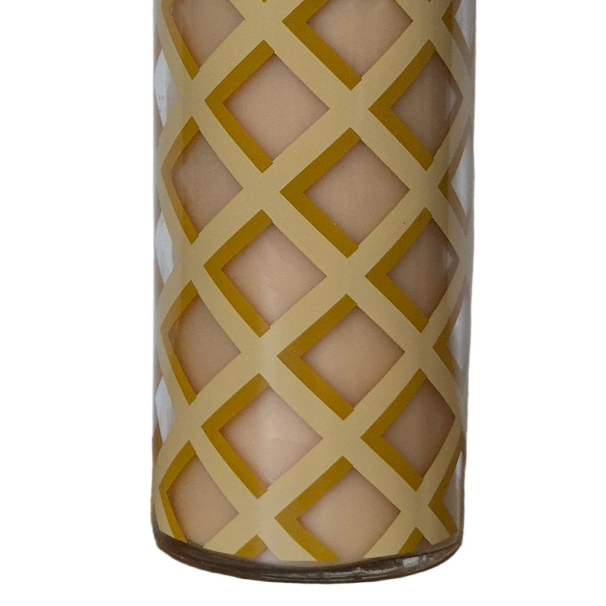 A close-up of a cylindrical glass candle holder with a geometric diamond lattice pattern, showing a beige wax candle inside against a white background.