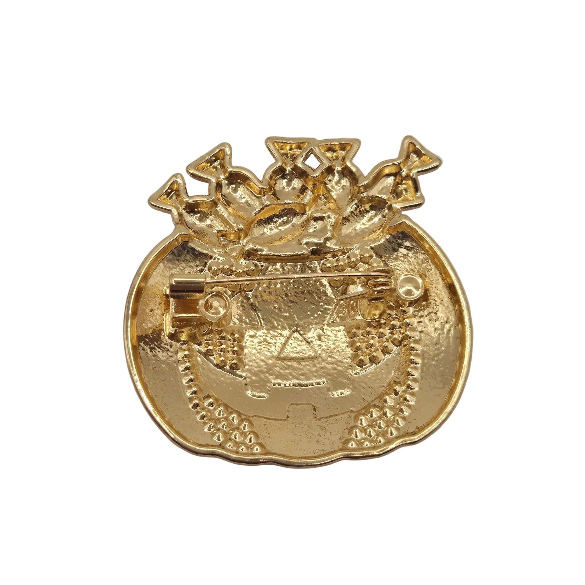 A Halloween-themed enamel pin shaped like a jack-o'-lantern pumpkin with candy overflowing from the top, showing the reverse side on a plain white background.
