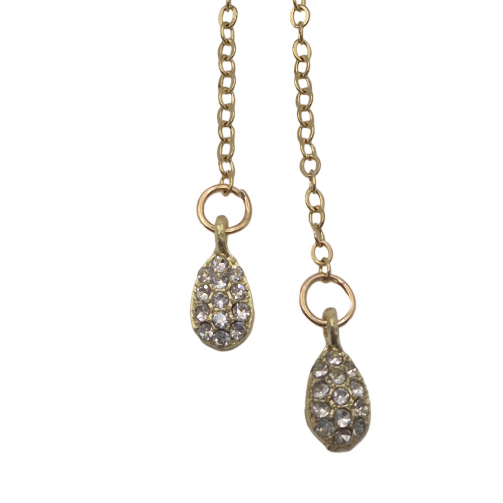A close up shot of pendant teardrop gems hanging from a brooch. Displayed against a plain white background.