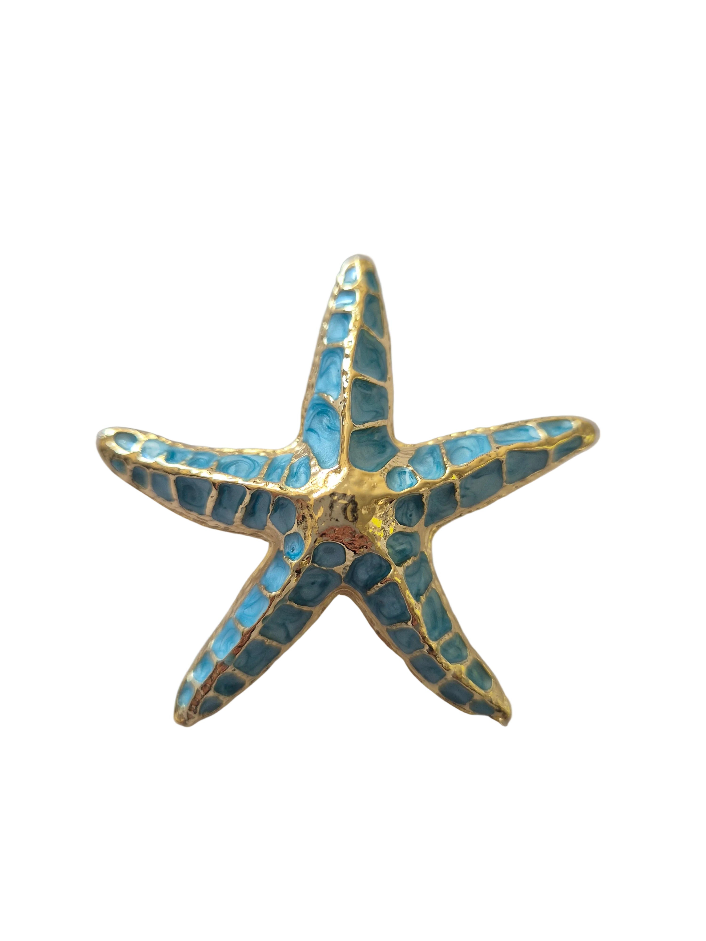 Starfish-shaped brooch with blue mosaic design on a white background