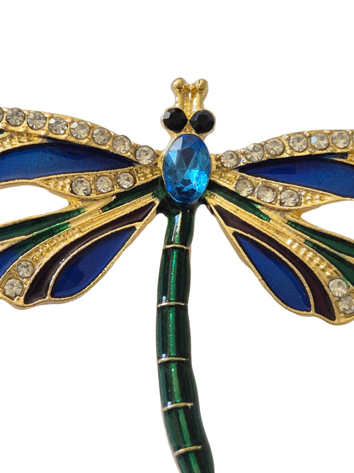 Decorative brooch shaped like a dragonfly with blue and green details on a white background