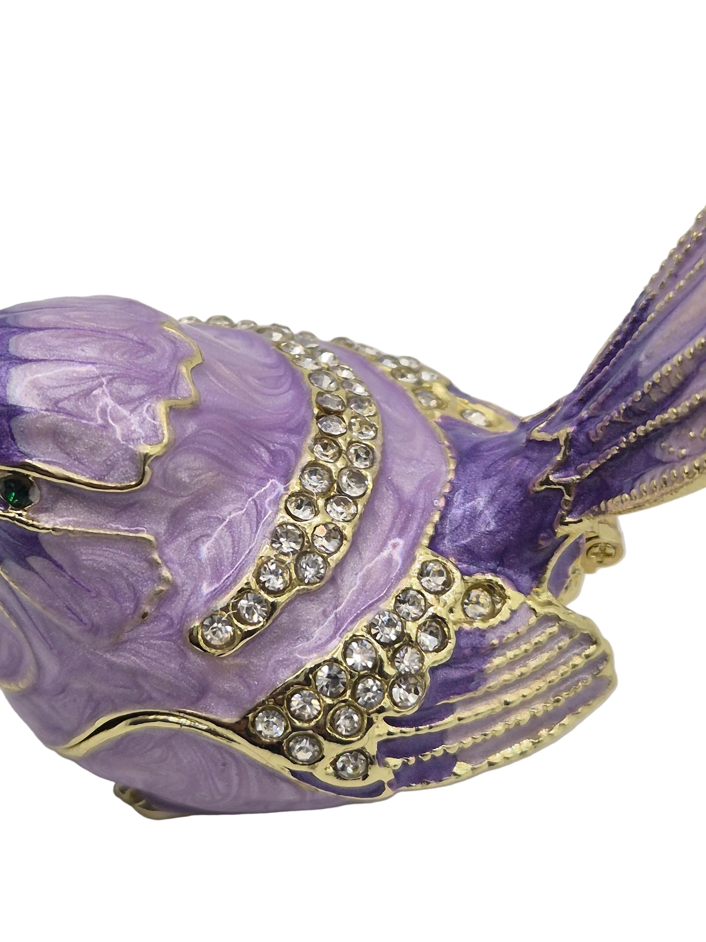 Decorative purple bird trinket pot with gold accents and rhinestones on a white background