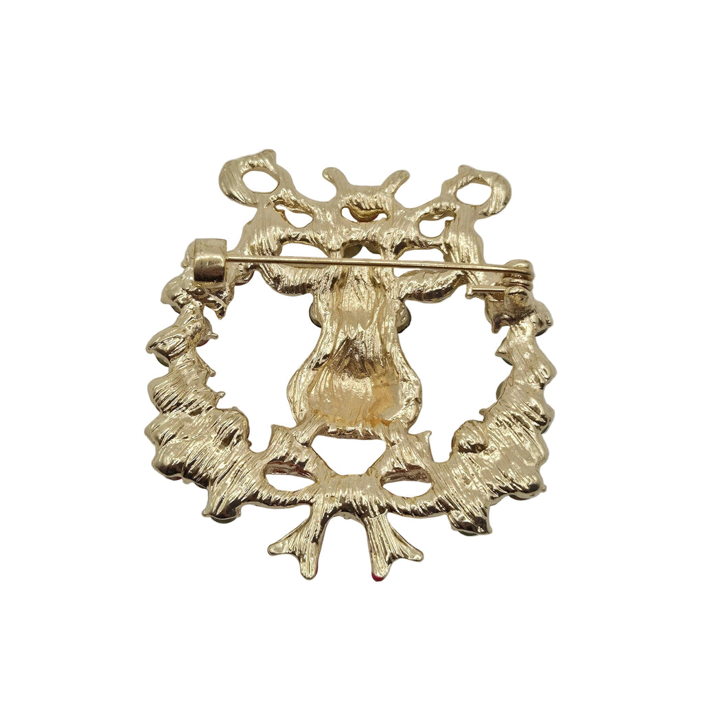 Reverse gold tone side of a reindeer Christmas brooch showing pin mechanism, displayed on a plain white background.