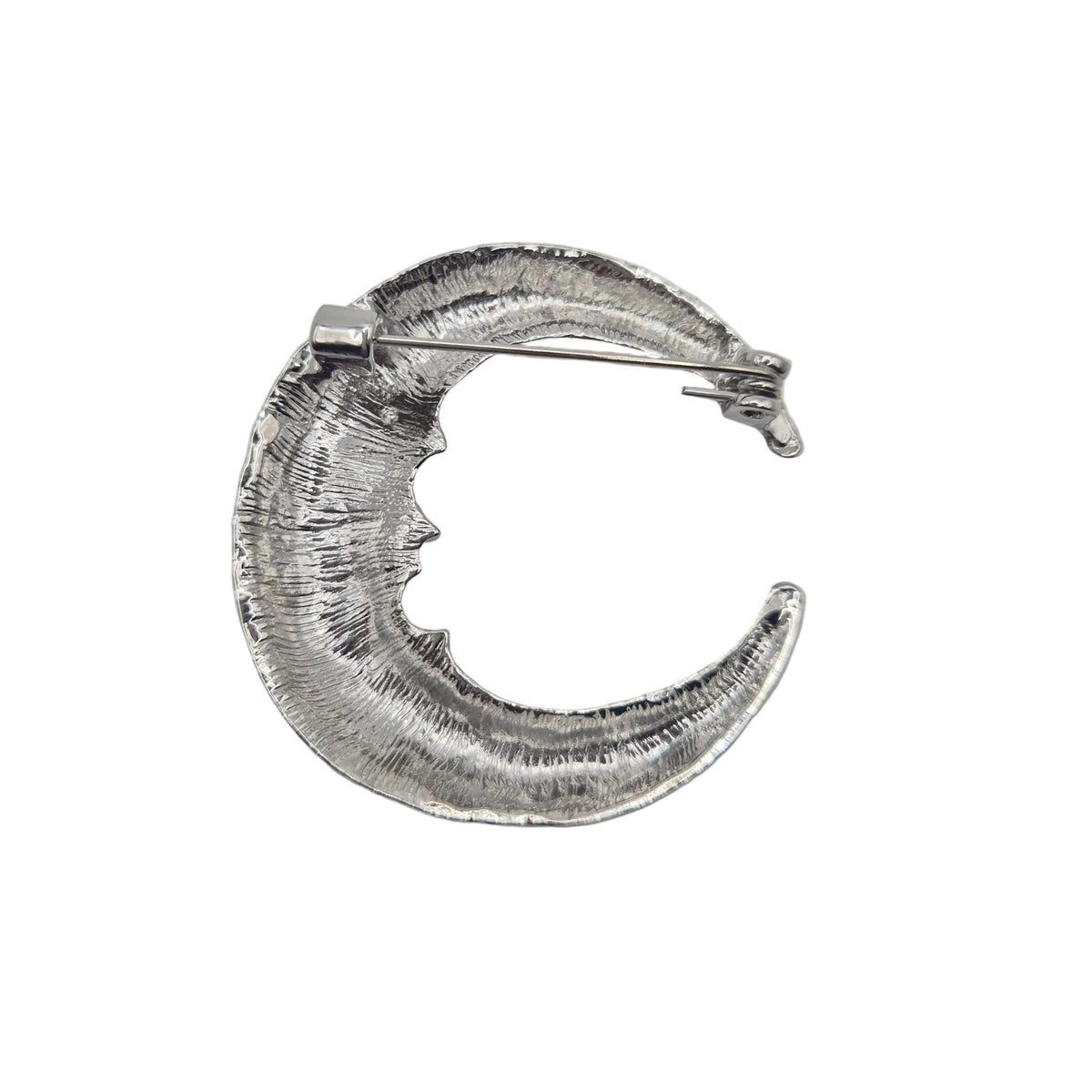 A textured silver crescent moon brooch showing the reverse side with a textured, hammered finish, shown on a plain light white background.