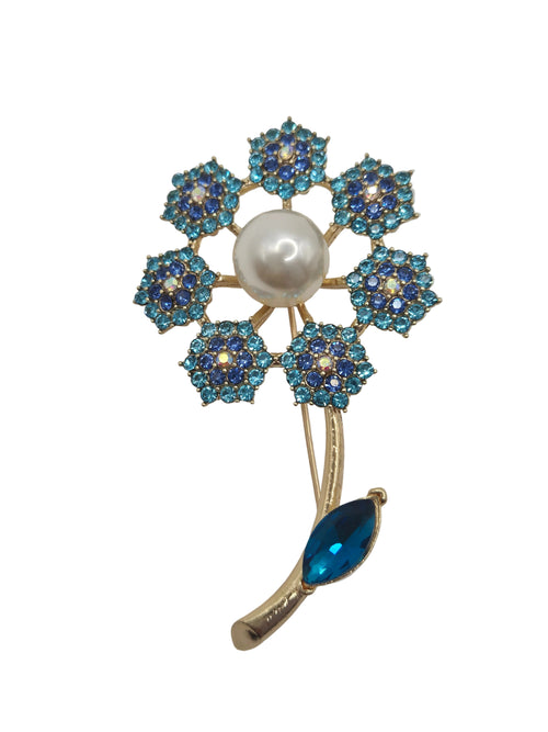 Decorative brooch with blue gemstones and a pearl on a gray background