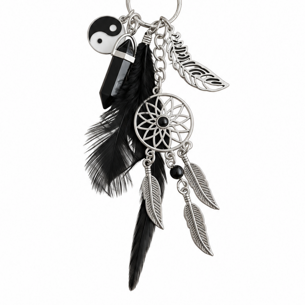 A silver-toned dreamcatcher keychain charm featuring a central webbed wheel, three hanging feathers, a black bead, a black crystal, and a black-and-white yin-yang symbol charm, shown on a plain white background.