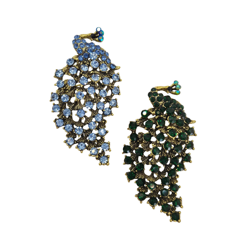 Two gold-tone peacock shaped rhinestone brooches on a plain white background. One brooch features light blue rhinestones, and the other features dark green rhinestones.