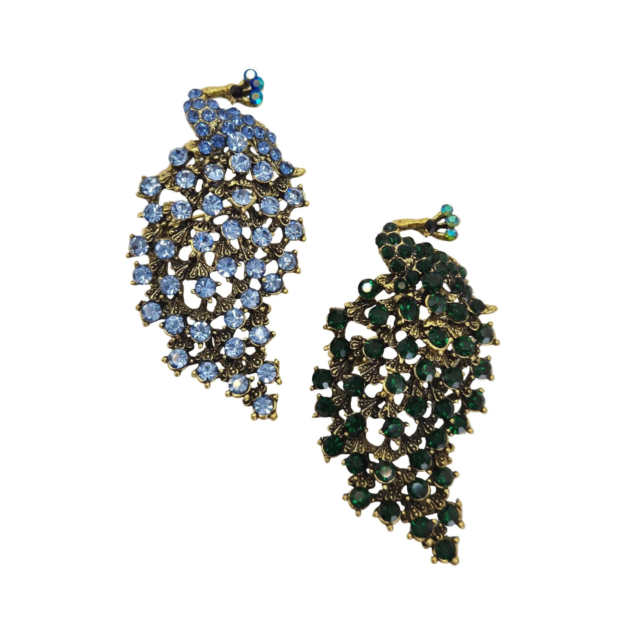 Two gold-tone peacock shaped rhinestone brooches on a plain white background. One brooch features light blue rhinestones, and the other features dark green rhinestones.