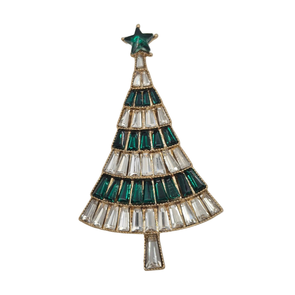 A Christmas tree-shaped brooch featuring alternating rows of emerald green and clear baguette crystals, topped with a green star, set in gold-toned metal against a white background.