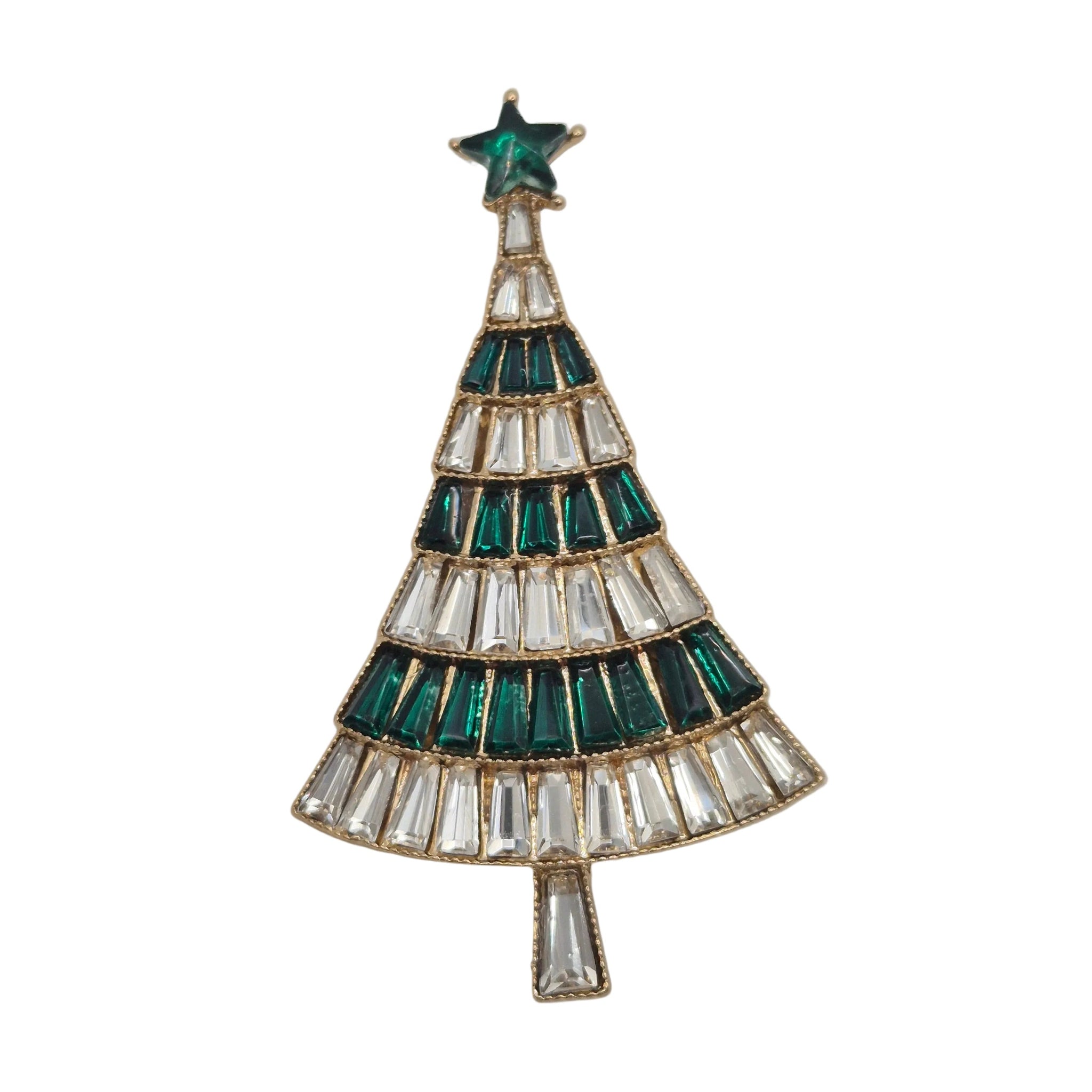 A Christmas tree-shaped brooch featuring alternating rows of emerald green and clear baguette crystals, topped with a green star, set in gold-toned metal against a white background.