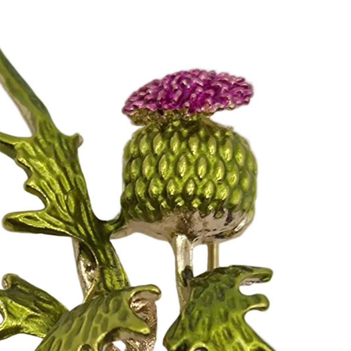 A close-up of a thistle brooch featuring a textured green seed head with a sparkling purple flower crown, set against a clean white background.