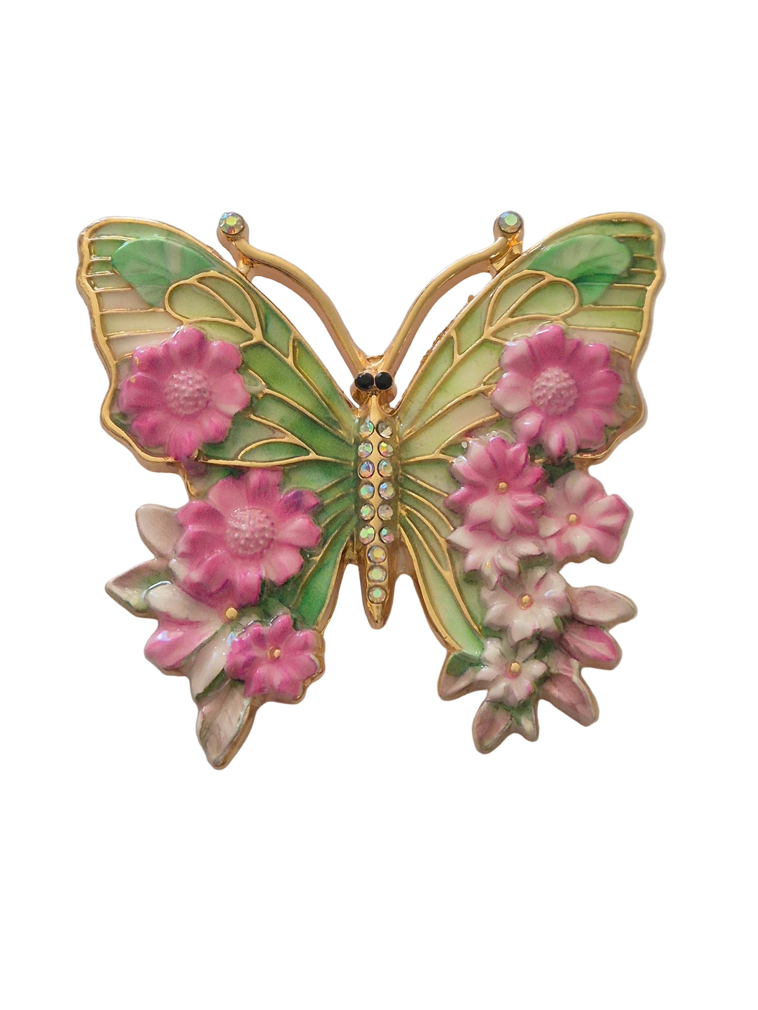 Butterfly-shaped brooch with floral design on a white background