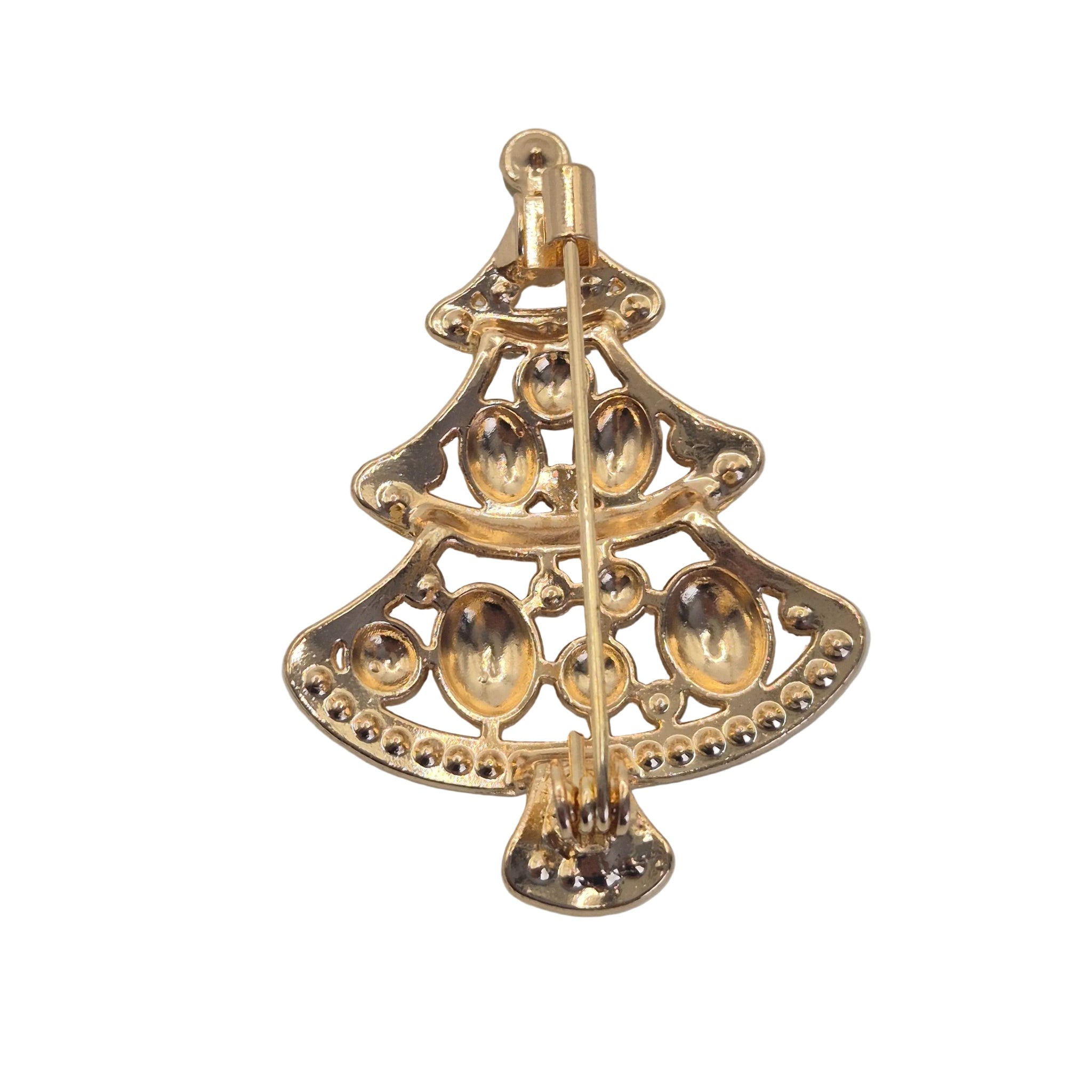A gold Christmas tree-shaped brooch with a pin-back fastener, featuring textured metallic details and small bead accents, shown on a neutral gray background.