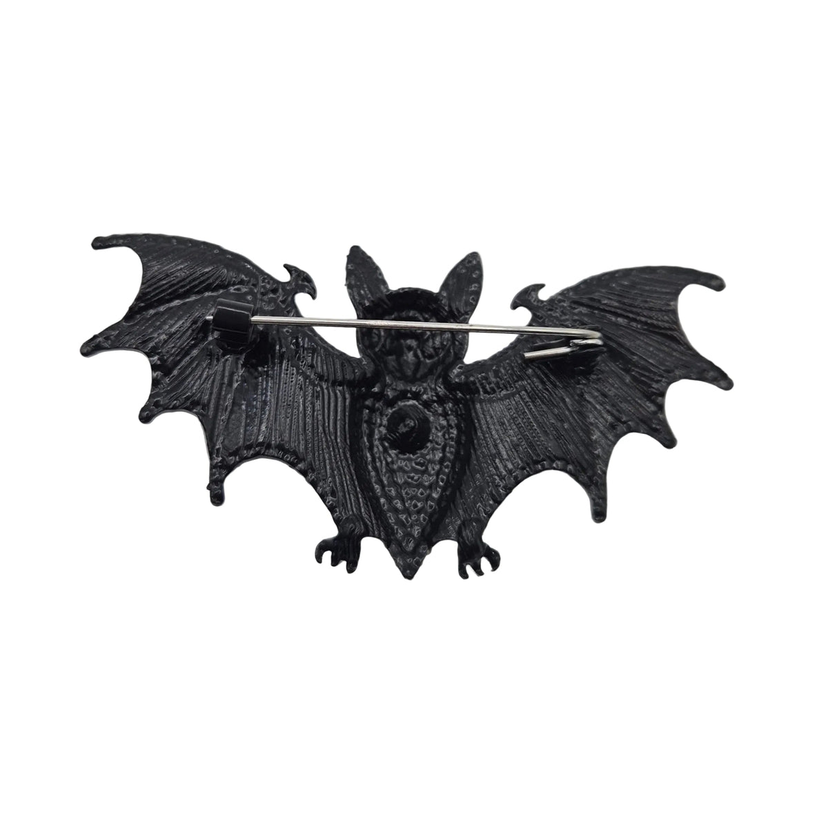 A black bat-shaped brooch with spread wings and a silver safety pin back, shown on a plain white background.