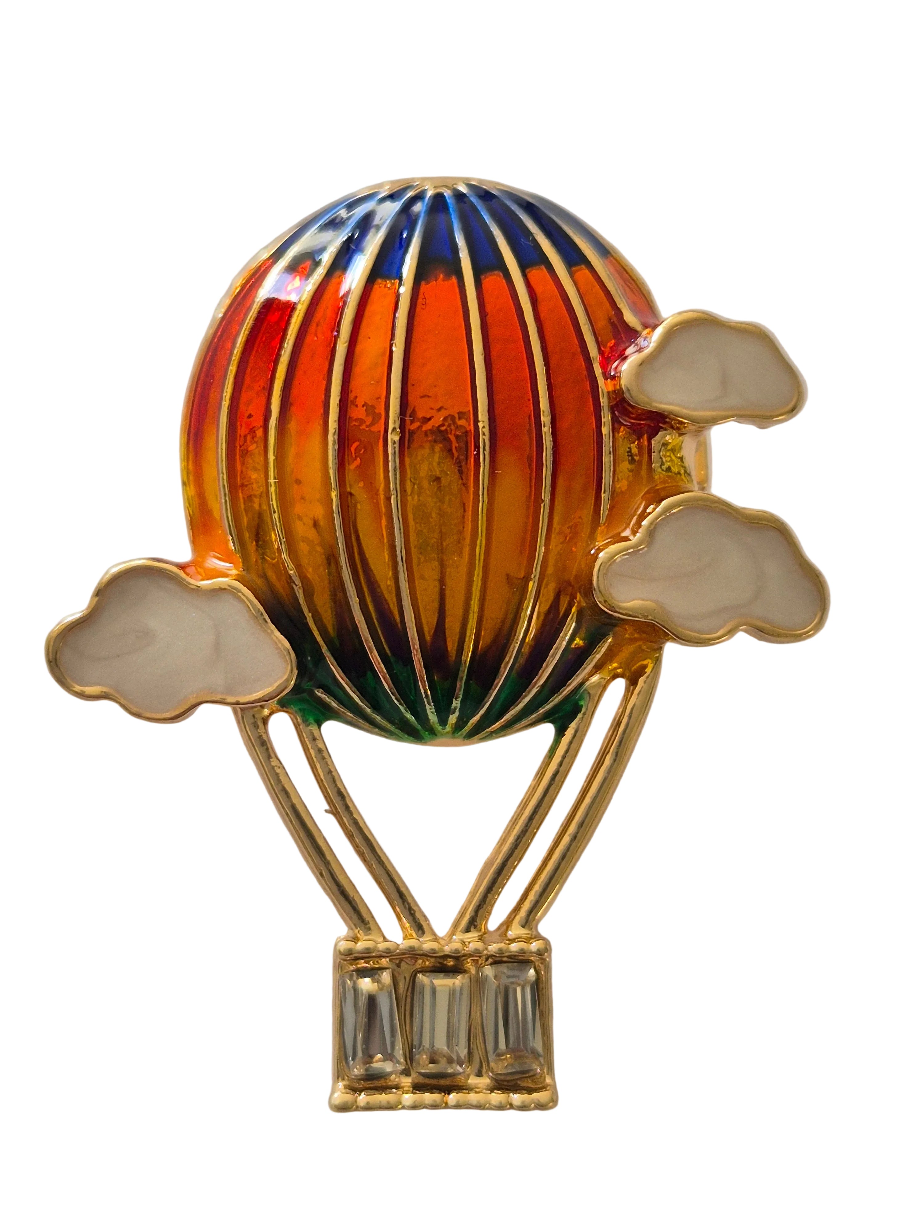 Colorful hot air balloon brooch with gold accents on a white background
