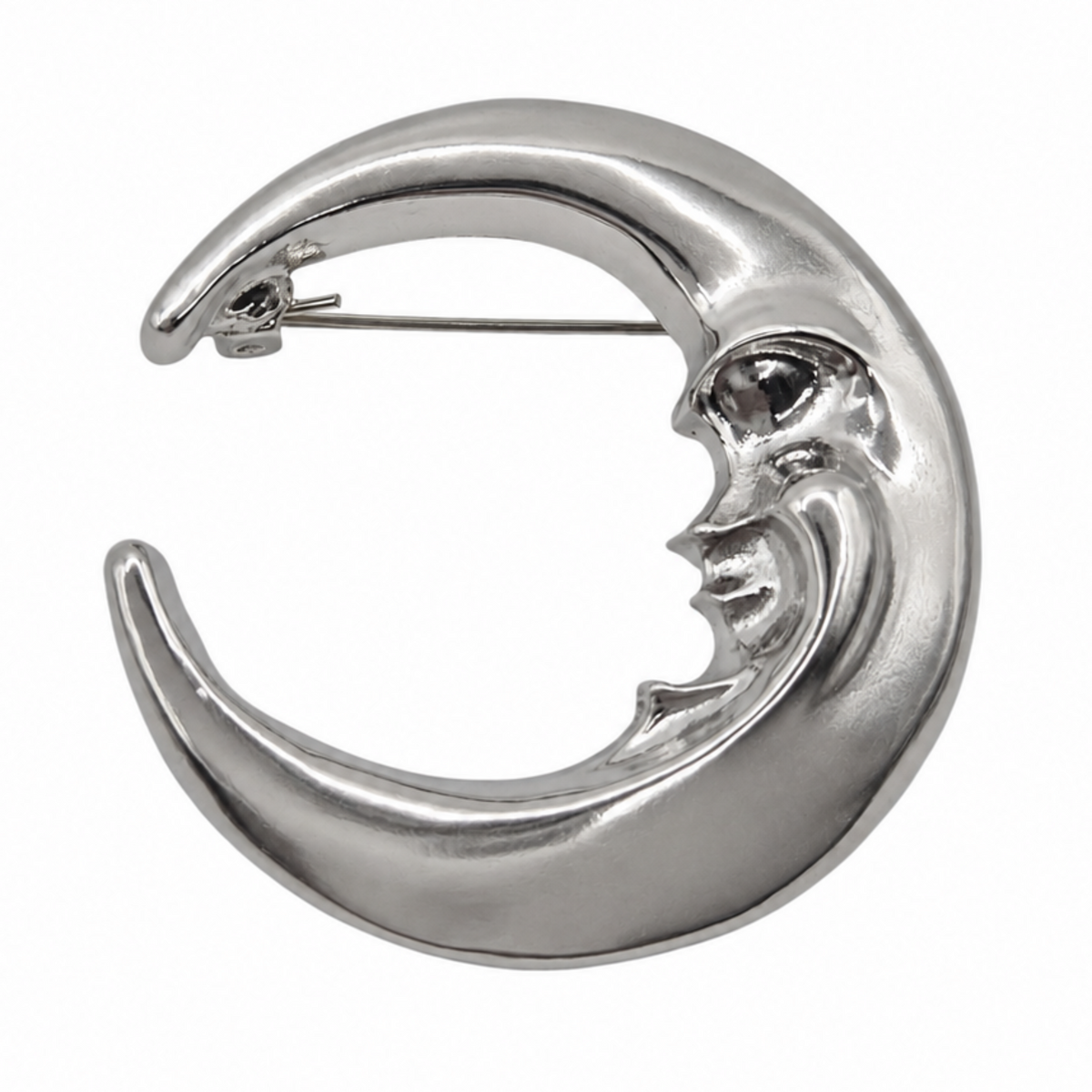 A polished silver crescent moon brooch with a stylized face, shown on a plain white background.