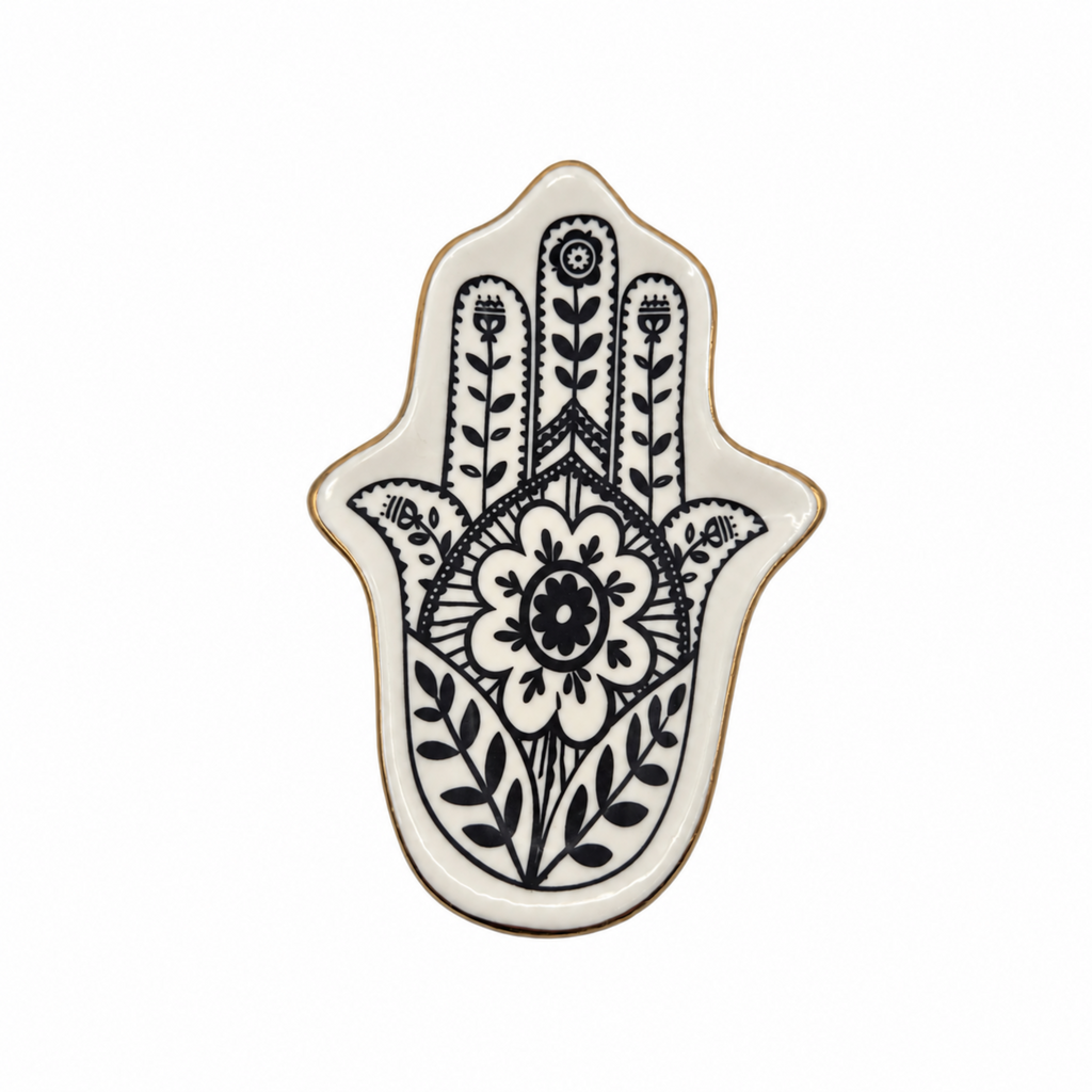 A ceramic Hamsa hand tray with a black floral and botanical handprint design on a white background, finished with a thin gold rim.