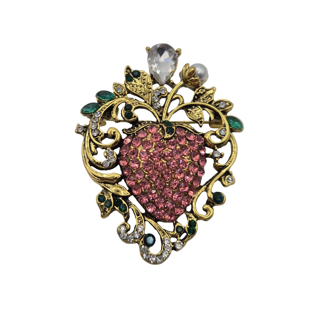 A vintage-style brooch featuring a heart-shaped centre paved with pink rhinestones, surrounded by ornate gold filigree with green and clear rhinestones, set against a plain white background.