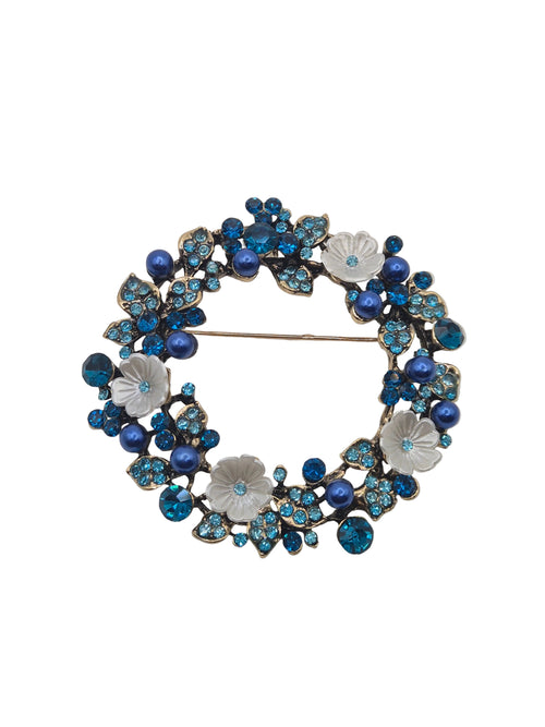 Decorative brooch with blue and white floral design on a white background
