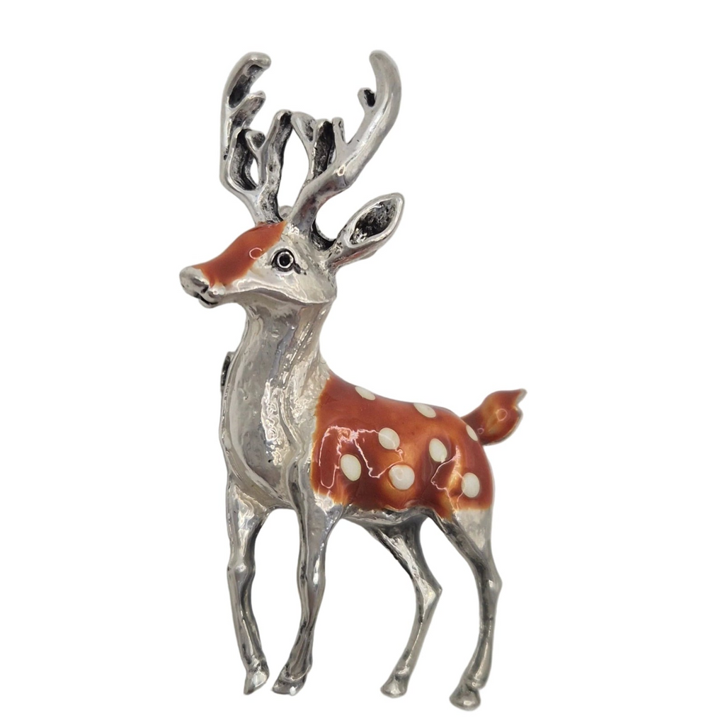 A deer-shaped brooch or pin with a silver-tone body and antlers, featuring reddish-brown enamel and white spots, shown on a plain white background.