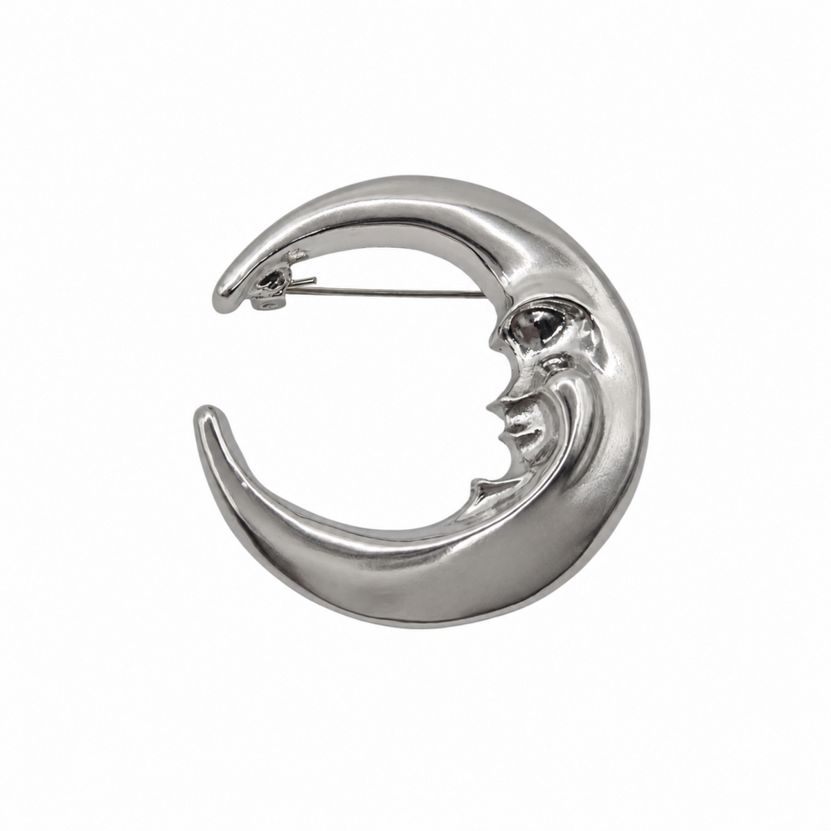 A polished silver crescent moon brooch with a stylized face, shown on a plain white background.