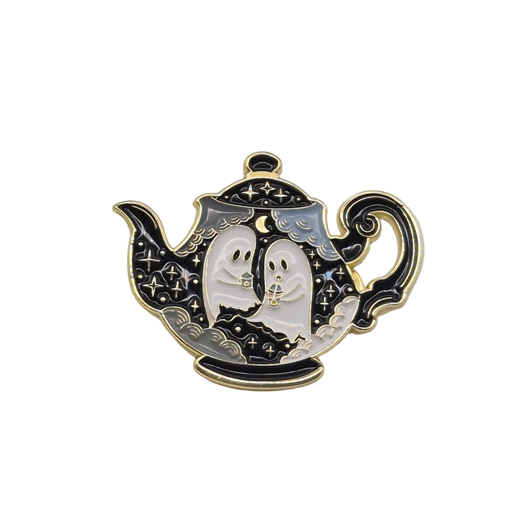 A Halloween-themed enamel pin shaped like a teapot, featuring two white ghosts with black outlines and gold trim against a black and silver patterned background.