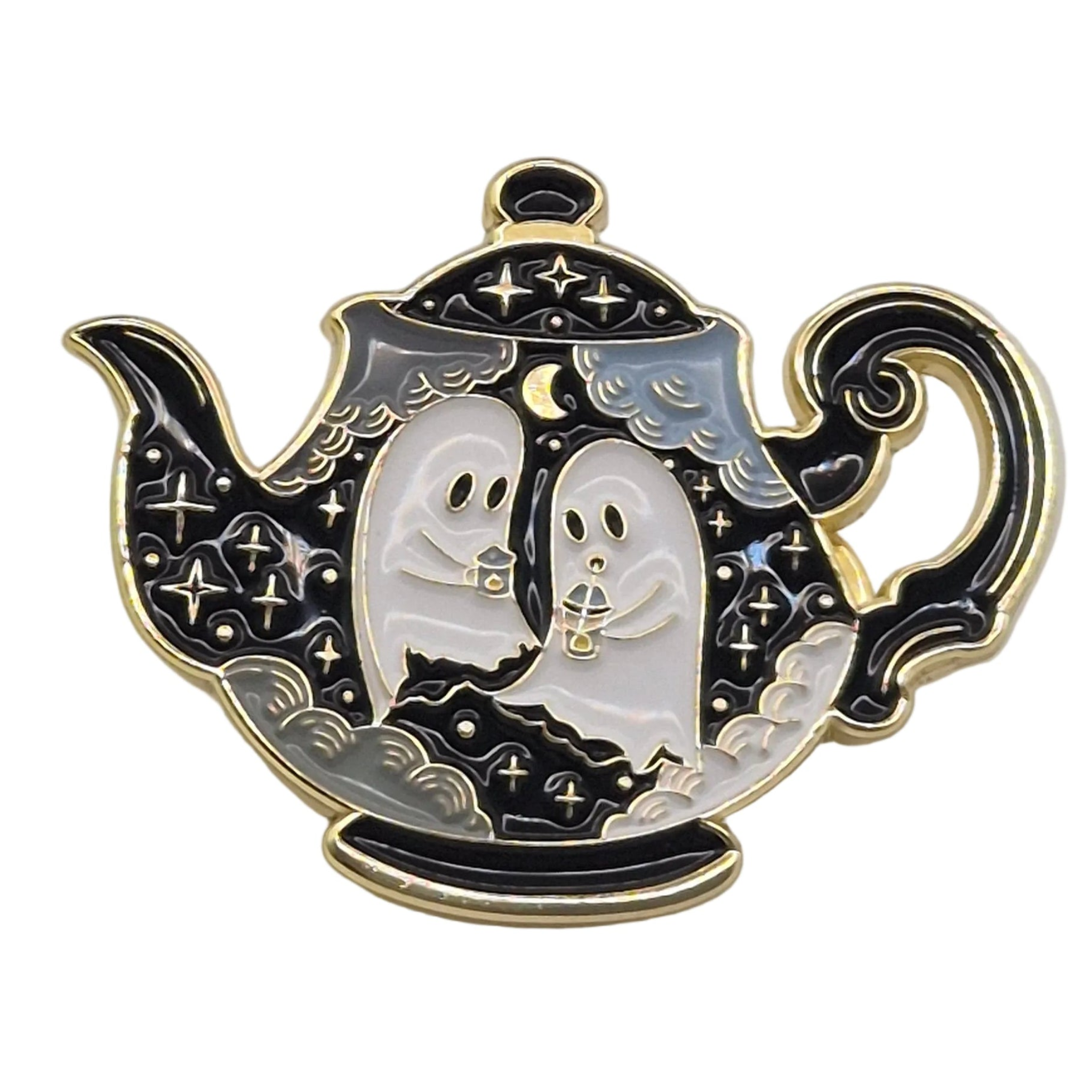 A teapot-shaped enamel pin featuring two ghost figures under a crescent moon and stars, with black, white, and gold colors on a plain white background.