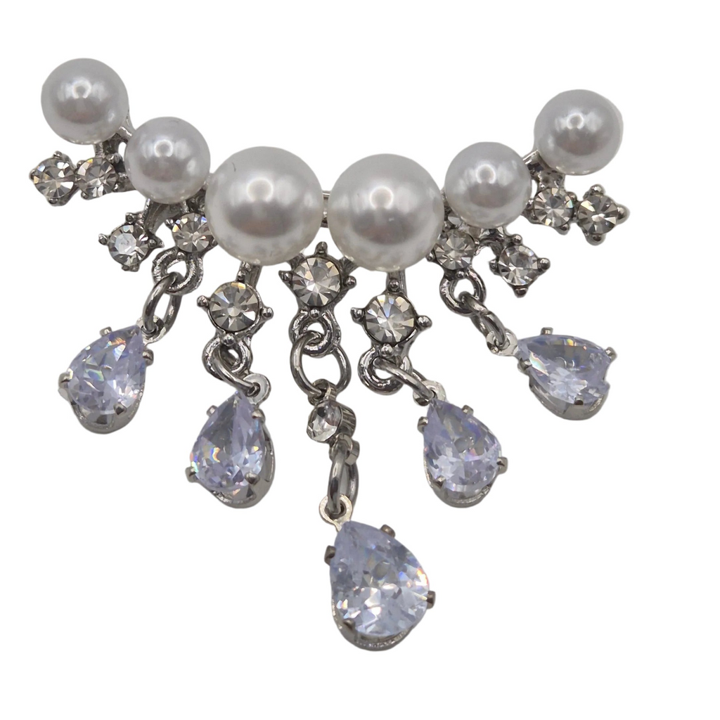 A silver-tone dangle brooch featuring white faux pearls and clear rhinestones, with five teardrop-shaped clear rhinestones hanging from silver chains, set against a plain white background. Shown close up.