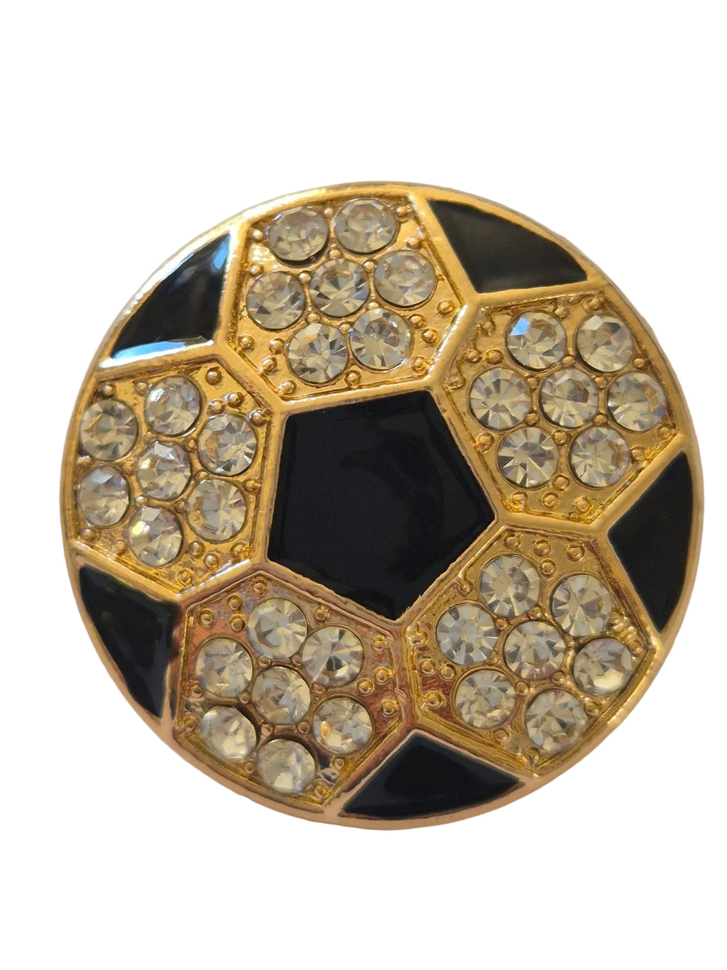 Decorative football brooch with gold and black design on a white background