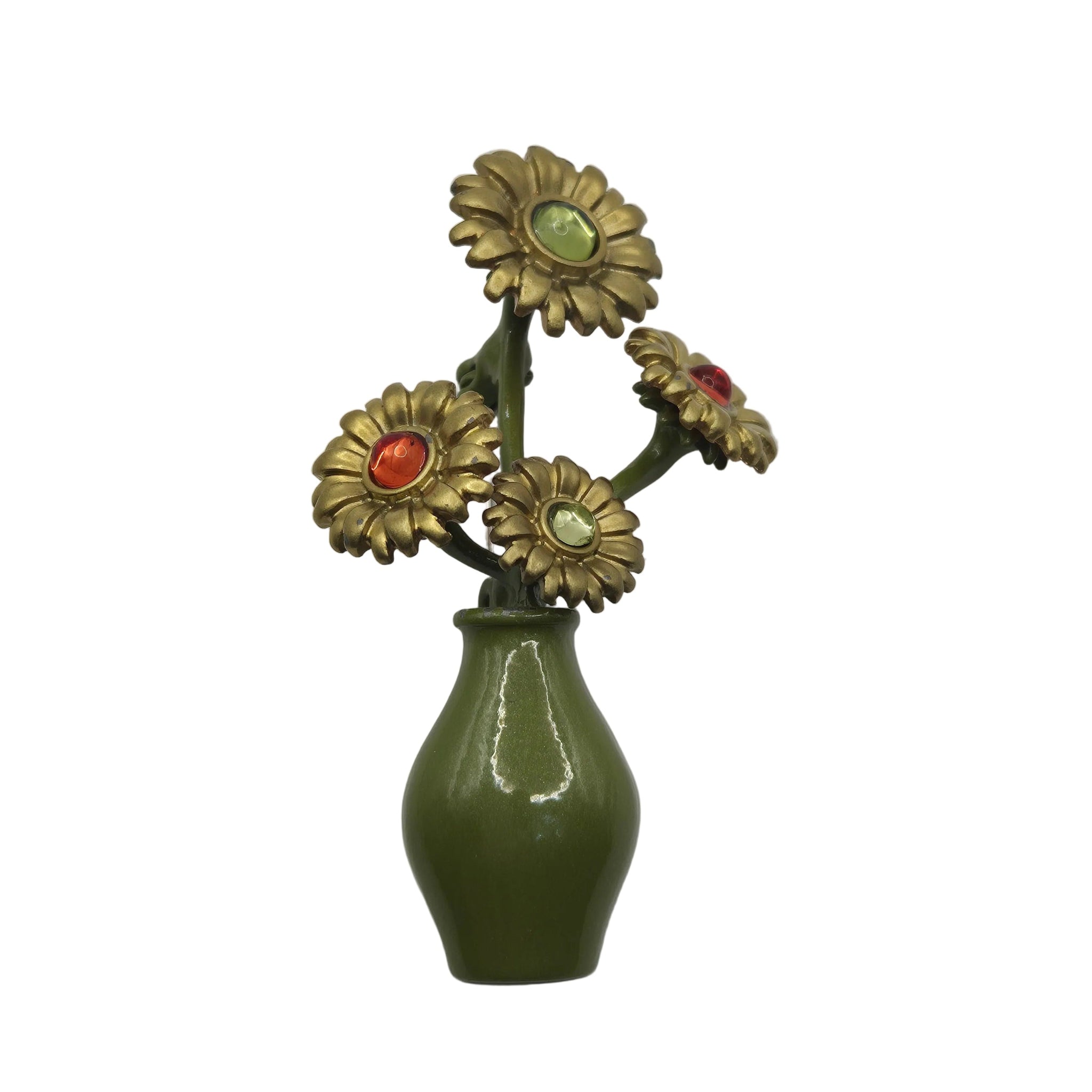A  brooch featuring decorative floral arrangement in a glossy olive green vase, featuring four gold-tone daisy-like flowers with colorful faceted centers in green, red, and light green, set against a plain white background.