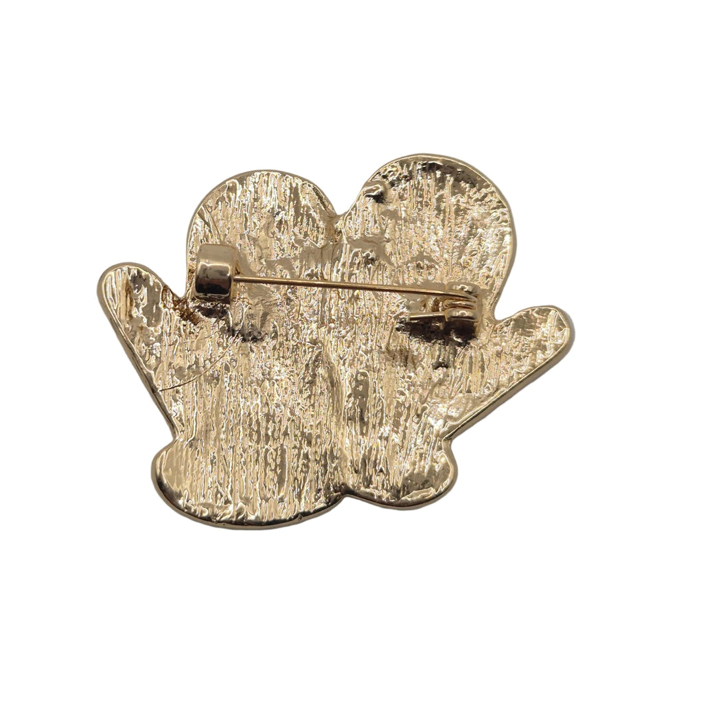 Reverse gold tone side of winter mittens brooch pin displaying pin mechanism, shown against a plain white background.