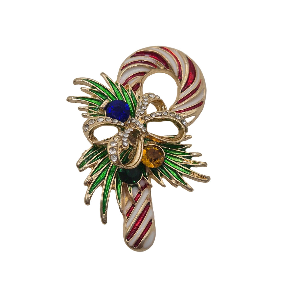 A gold-tone Christmas candy cane brooch featuring red and white striped candy canes, a green leafy wreath design, and colorful rhinestone accents in blue, yellow, and black, set against a plain white background.