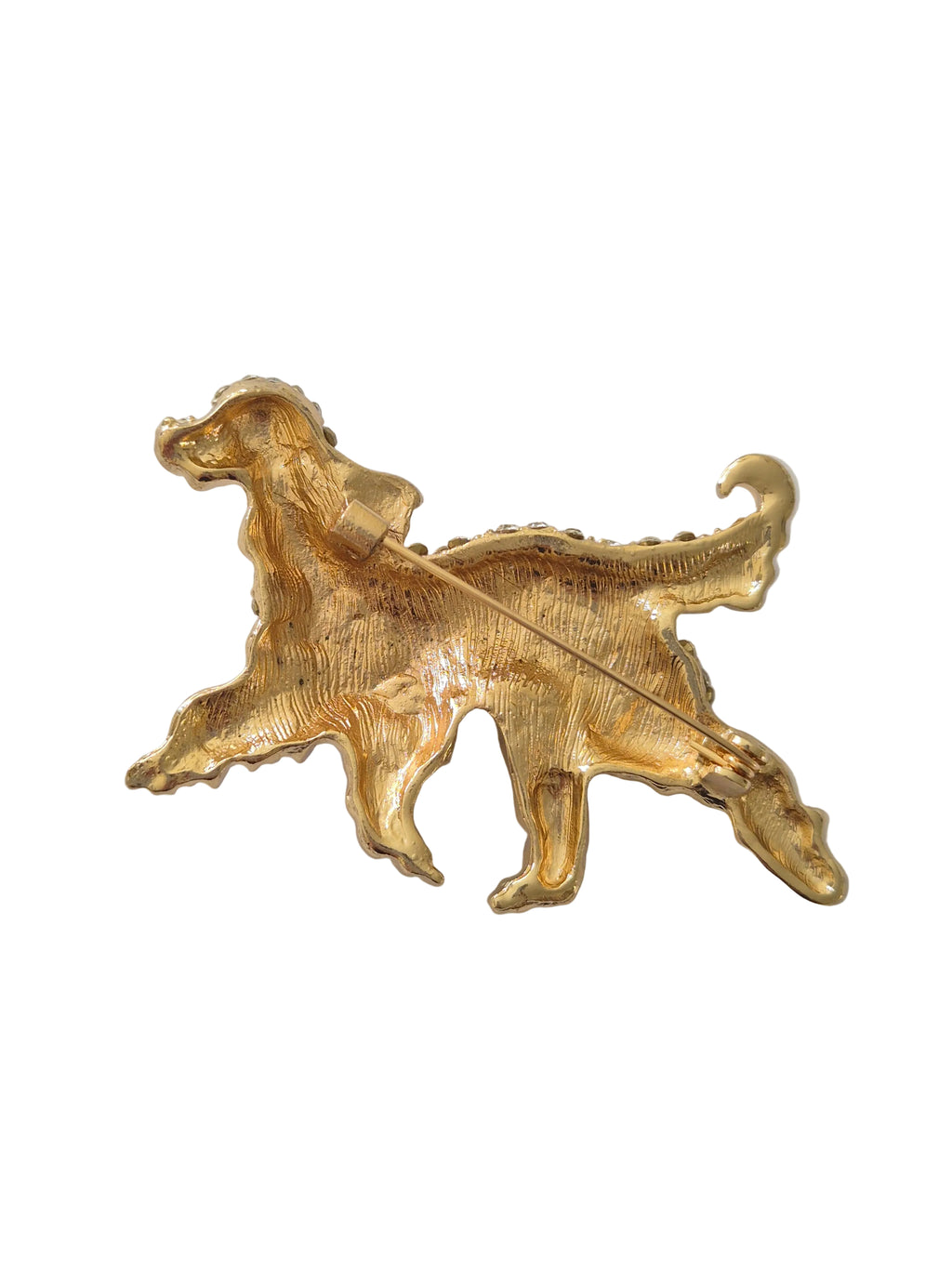 Gold dog-shaped brooch on a white background