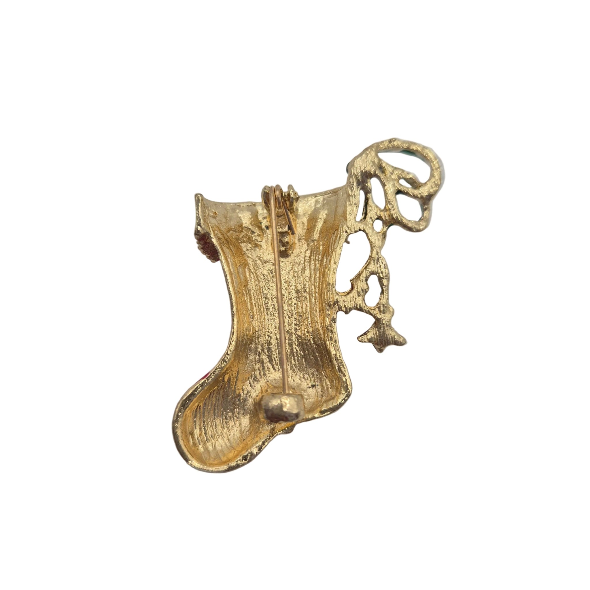 A textured gold-coloured metal brooch shaped like a stylized boot with an intricate loop at the top, photographed on a plain light white background.