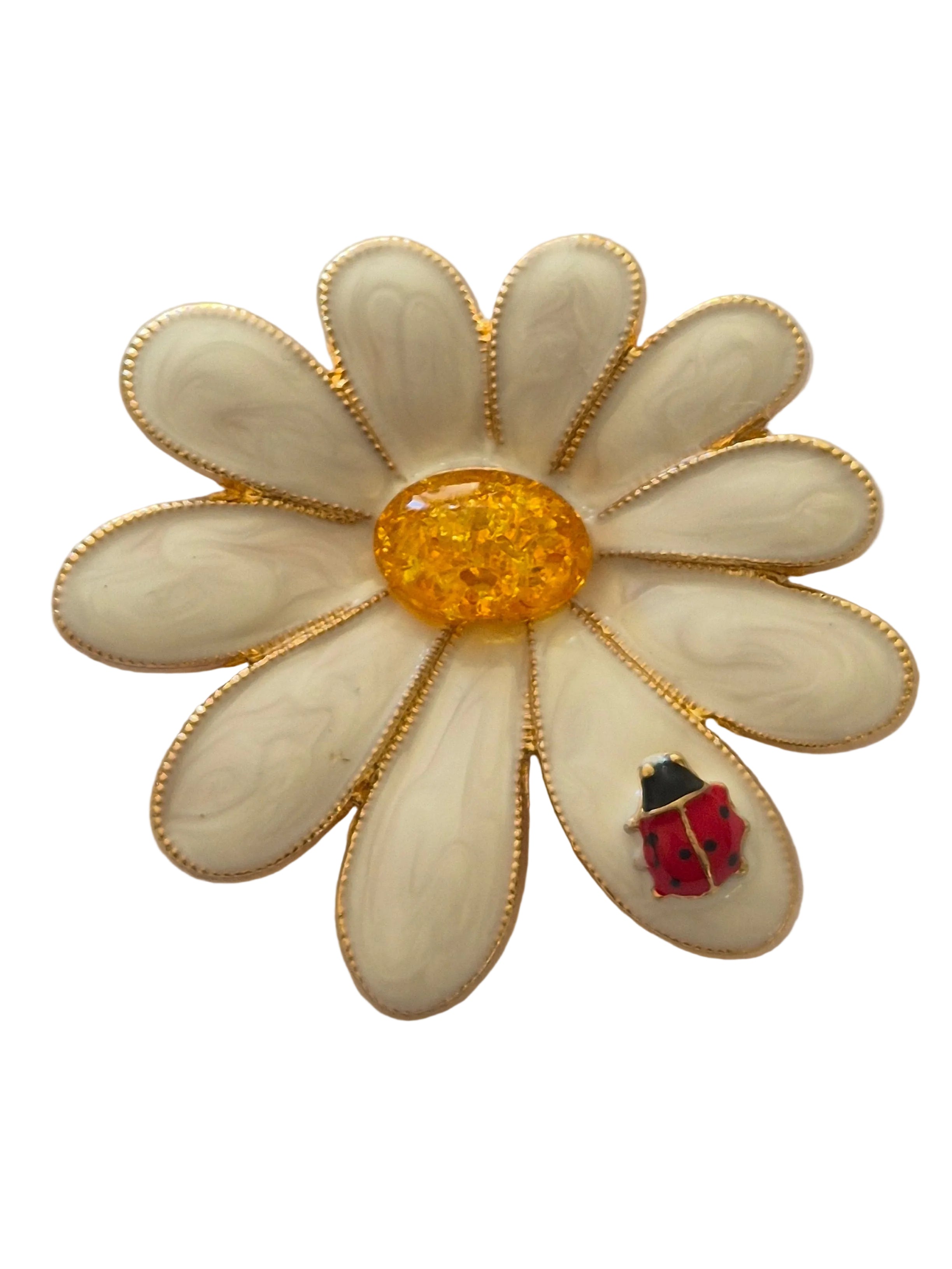 Daisy flower brooch with a yellow center and red insect on a white background
