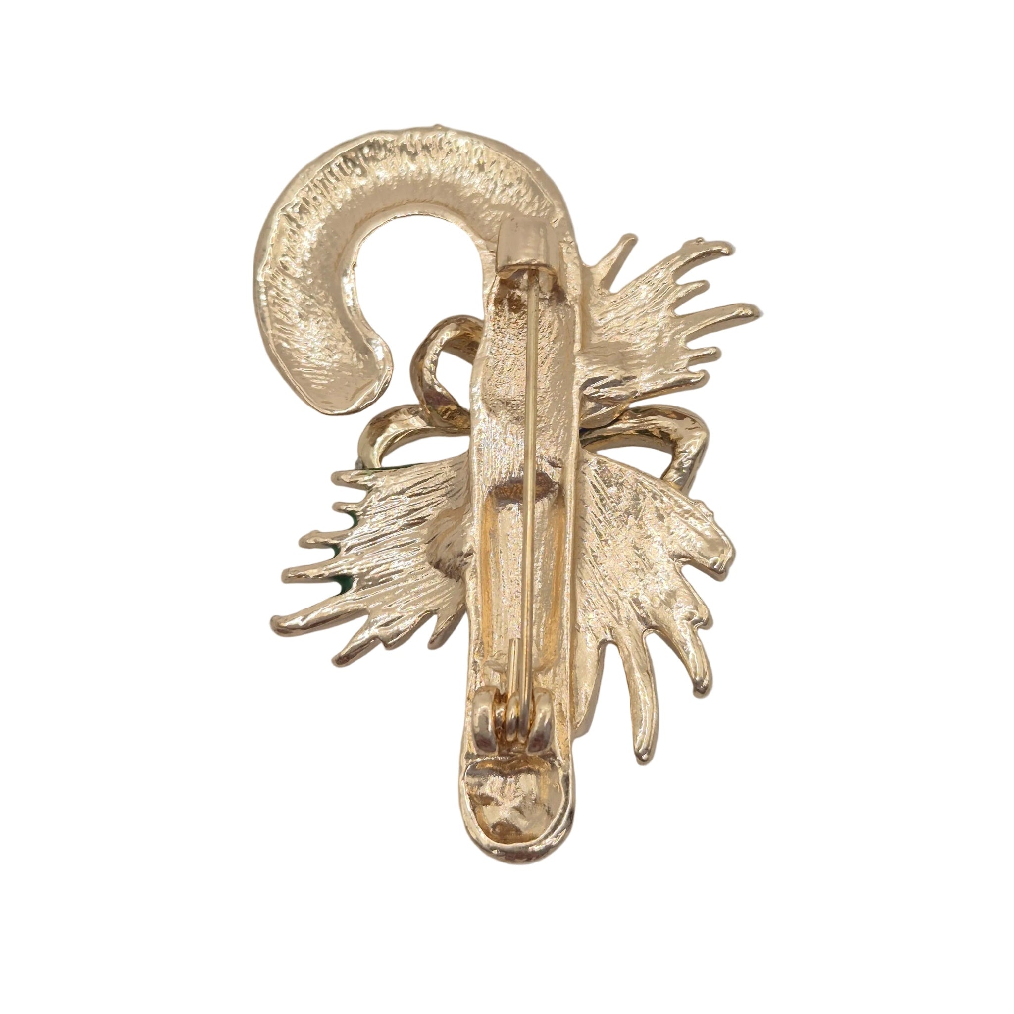 A gold-toned candy cane brooch, photographed on a plain light white background.