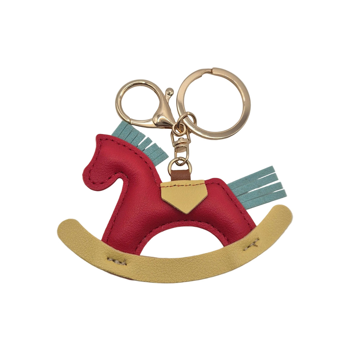 A miniature rocking horse keychain charm featuring a red body, light blue fringe mane and tail, and a yellow curved rocking base, attached to gold-tone metal rings on a plain white background.