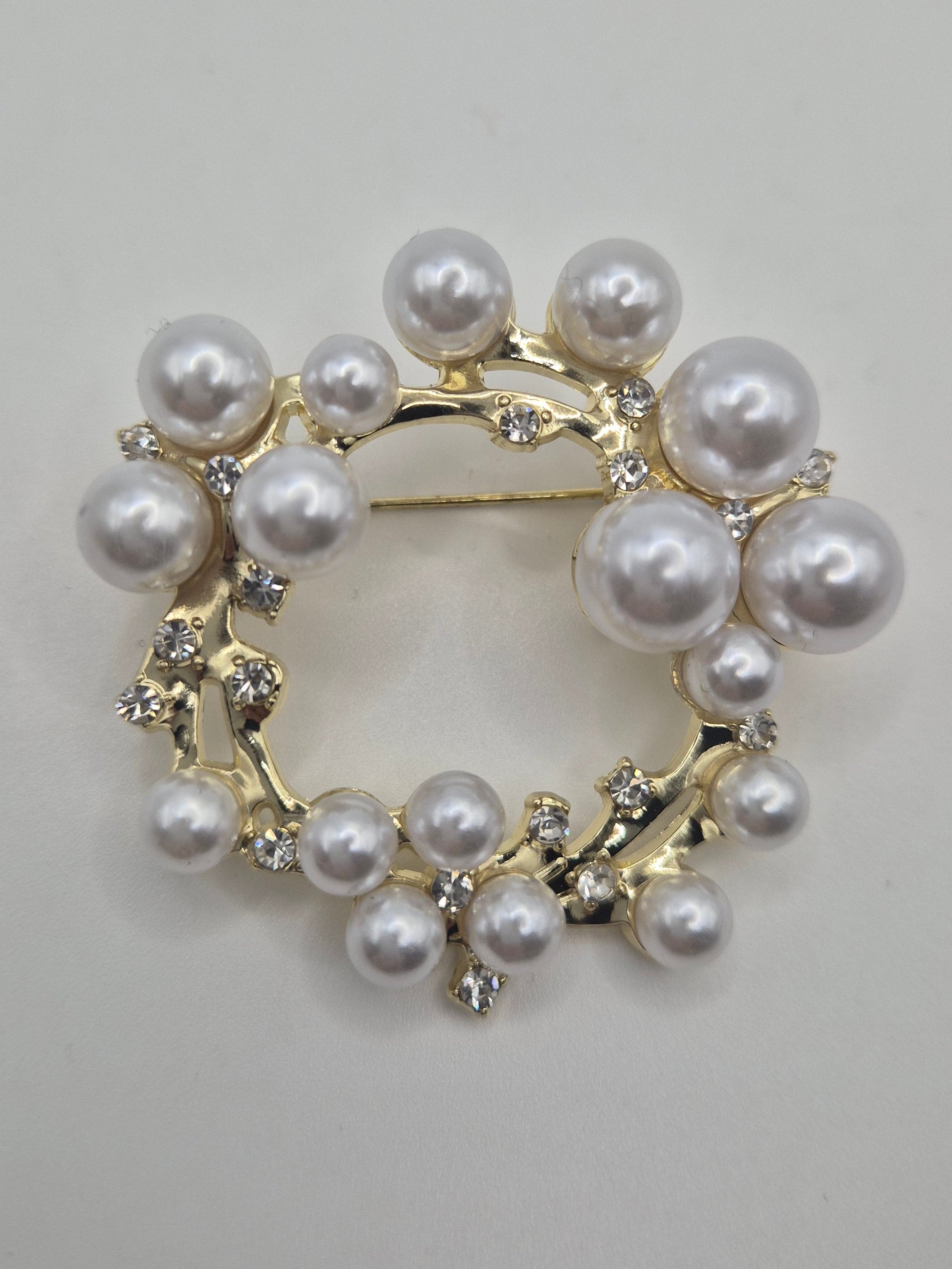 Circular brooch with pearls on a light gray background