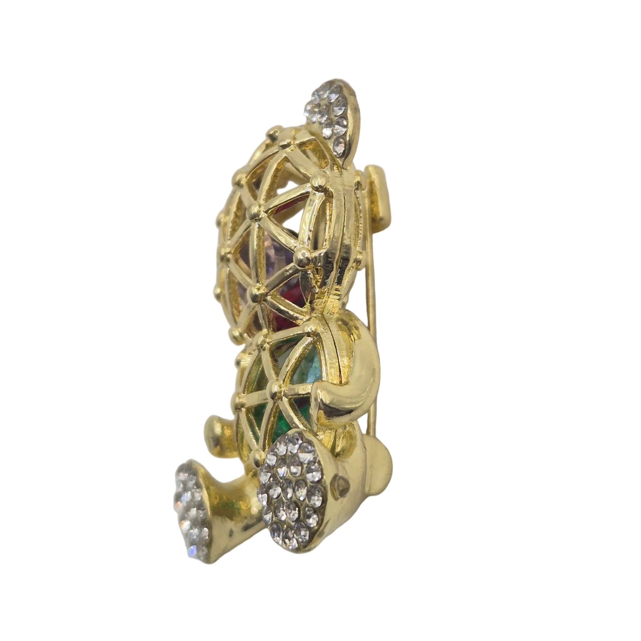 A gold-toned bear shaped brooch featuring rhinestone-encrusted details and small multicolor enamel accents, shown on a plain white background.