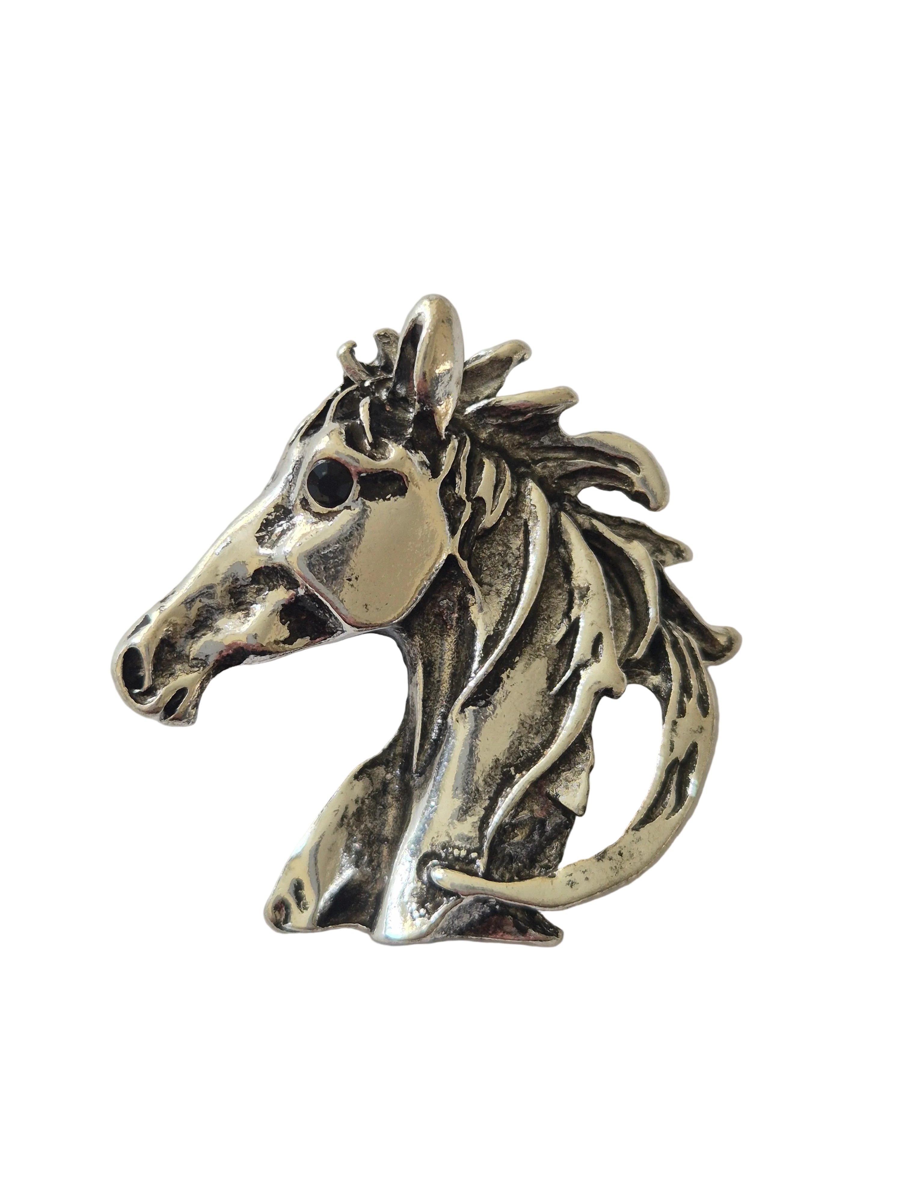 Silver horse head brooch on a white background